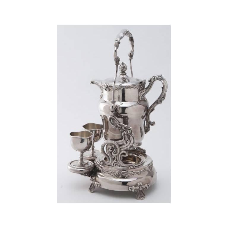 Elegant antique silver plated Art Nouveau samovar with a pair of goblets and a porcelain liner to the tilting water or tea pitcher, circa 1890. Marked 