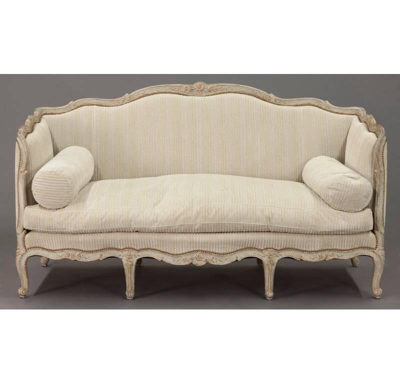 Add French elegance to your home with this Louis XV antique painted sofa. Crafted in France, circa 1860, this canape stands on eight cabriole legs over a serpentine shaped seat and an undulating crest extending over two end panels and large back. It