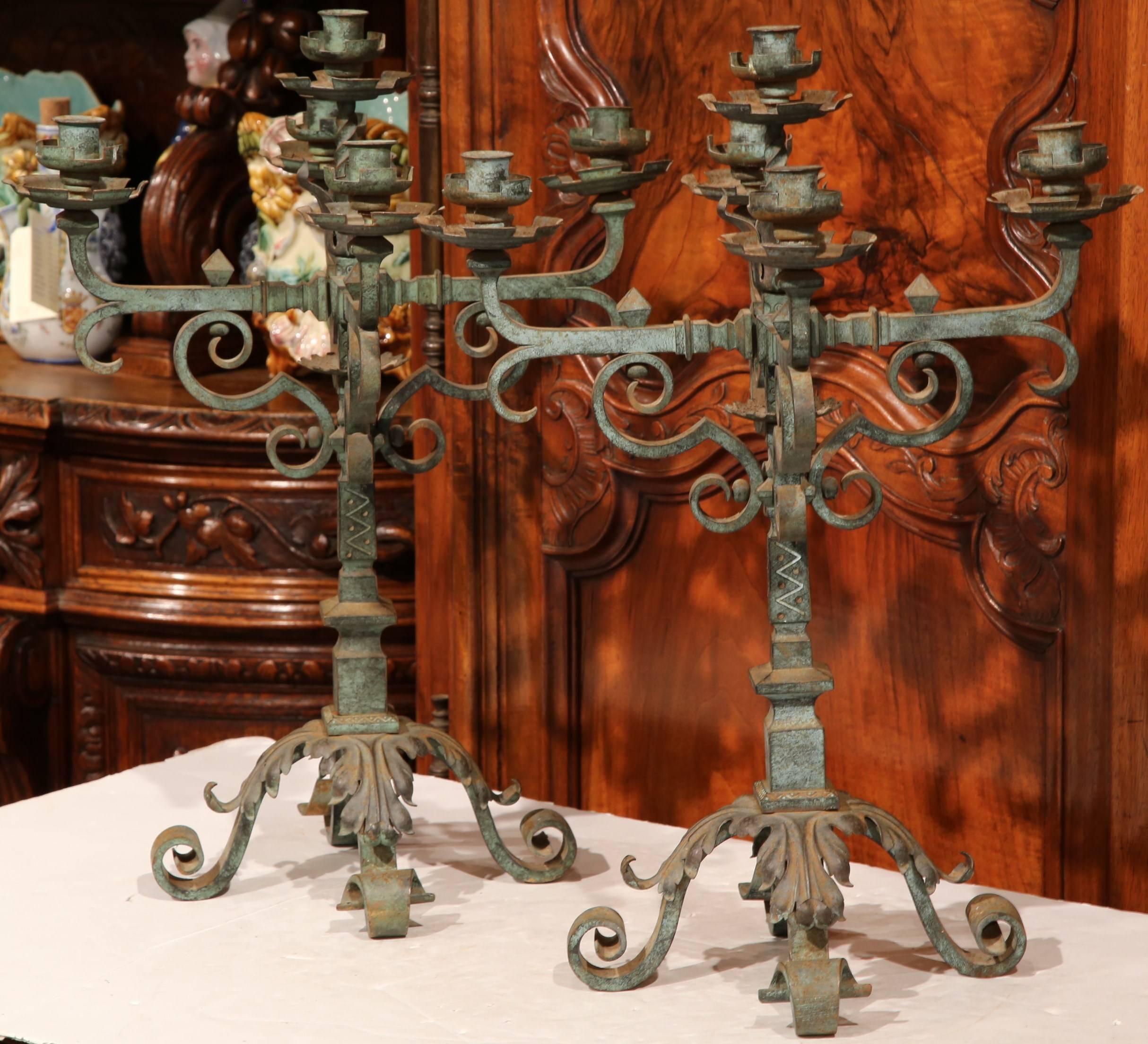 Heavy pair of antique Gothic hand-forged candelabras from a chateau in Dordogne, France, circa 1800. With four arms and a center one, each piece can hold five candles. Beautiful wrought iron work with original verdigris finish. Excellent condition.