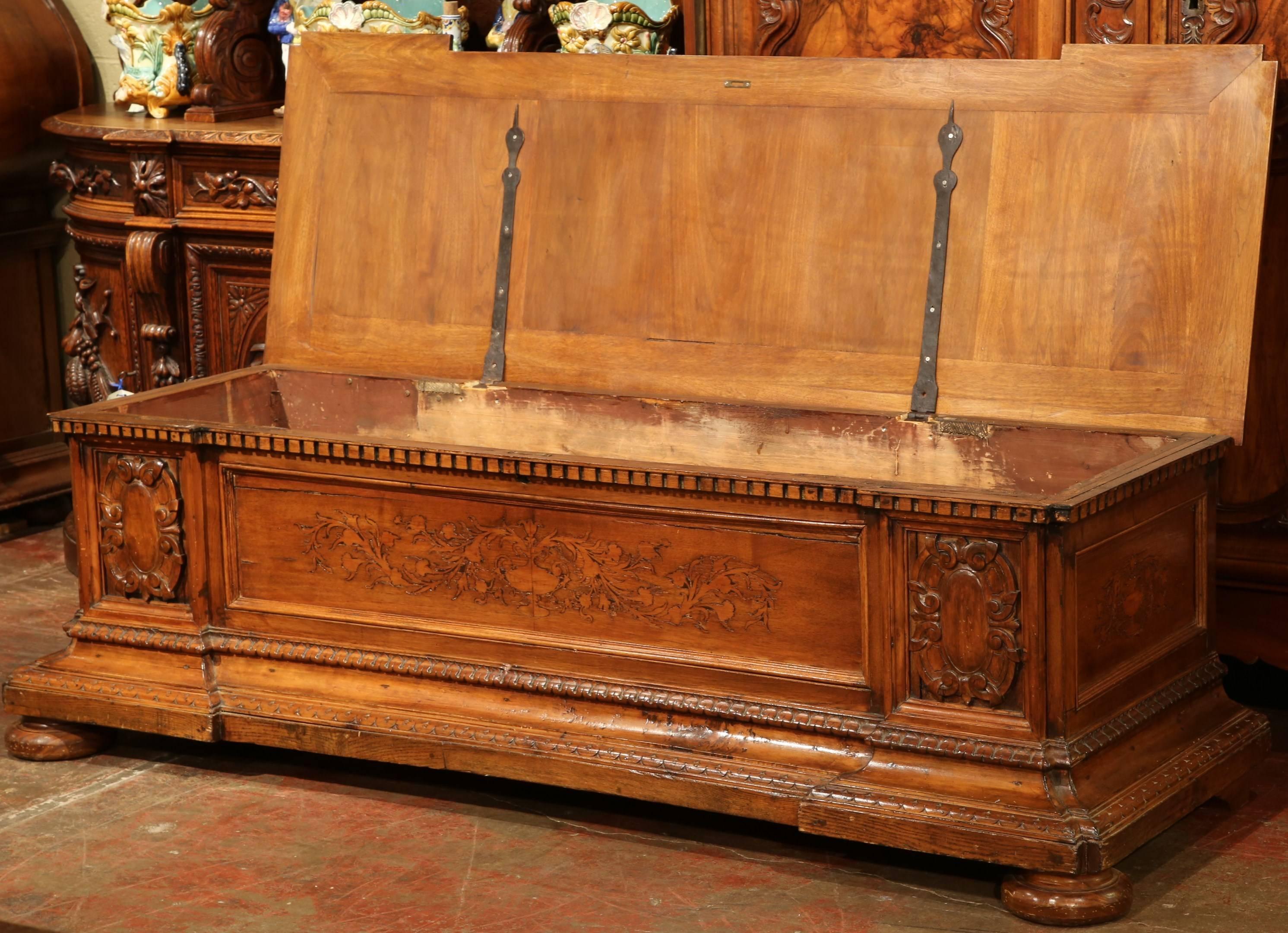 Place this large antique fruitwood blanket chest at the foot of any king-size bed, or in an entry! Crafted in the Alps mountains of France, circa 1860, the trunk features marquetry inlay decor with flowers on the facade and both sides, a pair of