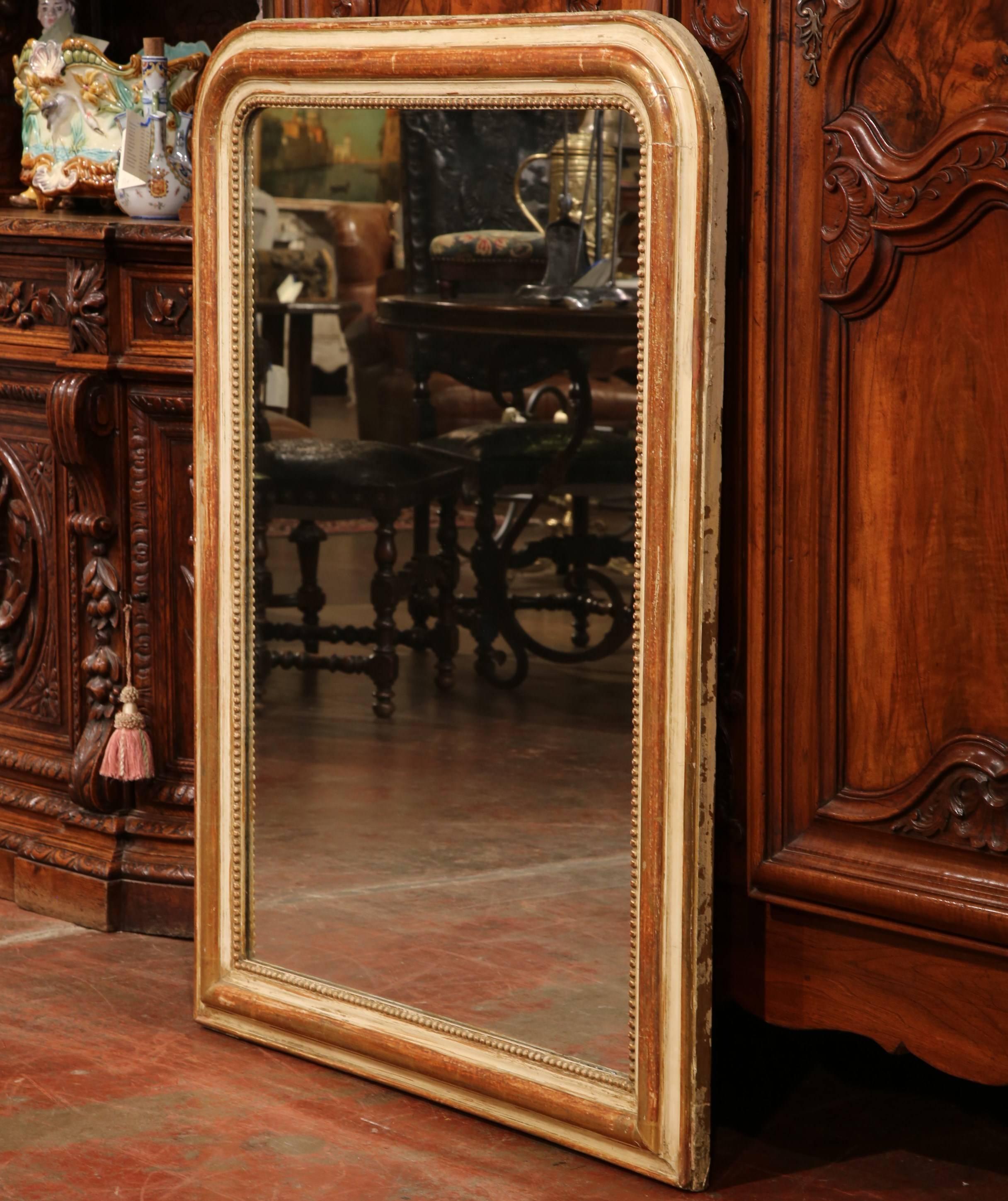 Decorate a entry or a powder room with this elegant antique mirror. Crafted in France, circa 1870, the rectangular wall piece with rounded corners and decorative beads around the frame, features a two-tone red and off white gesso finish over the