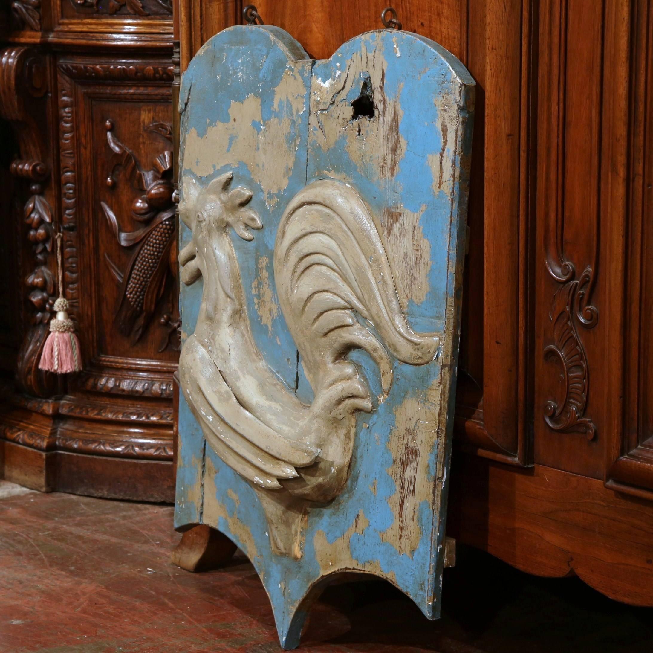 This antique wooden signboard was crafted in France, circa 1780. Interesting in shape and in excellent condition, the board features a French rooster in tole relief. Both the board and bird have the original blue paint finish and the original chain