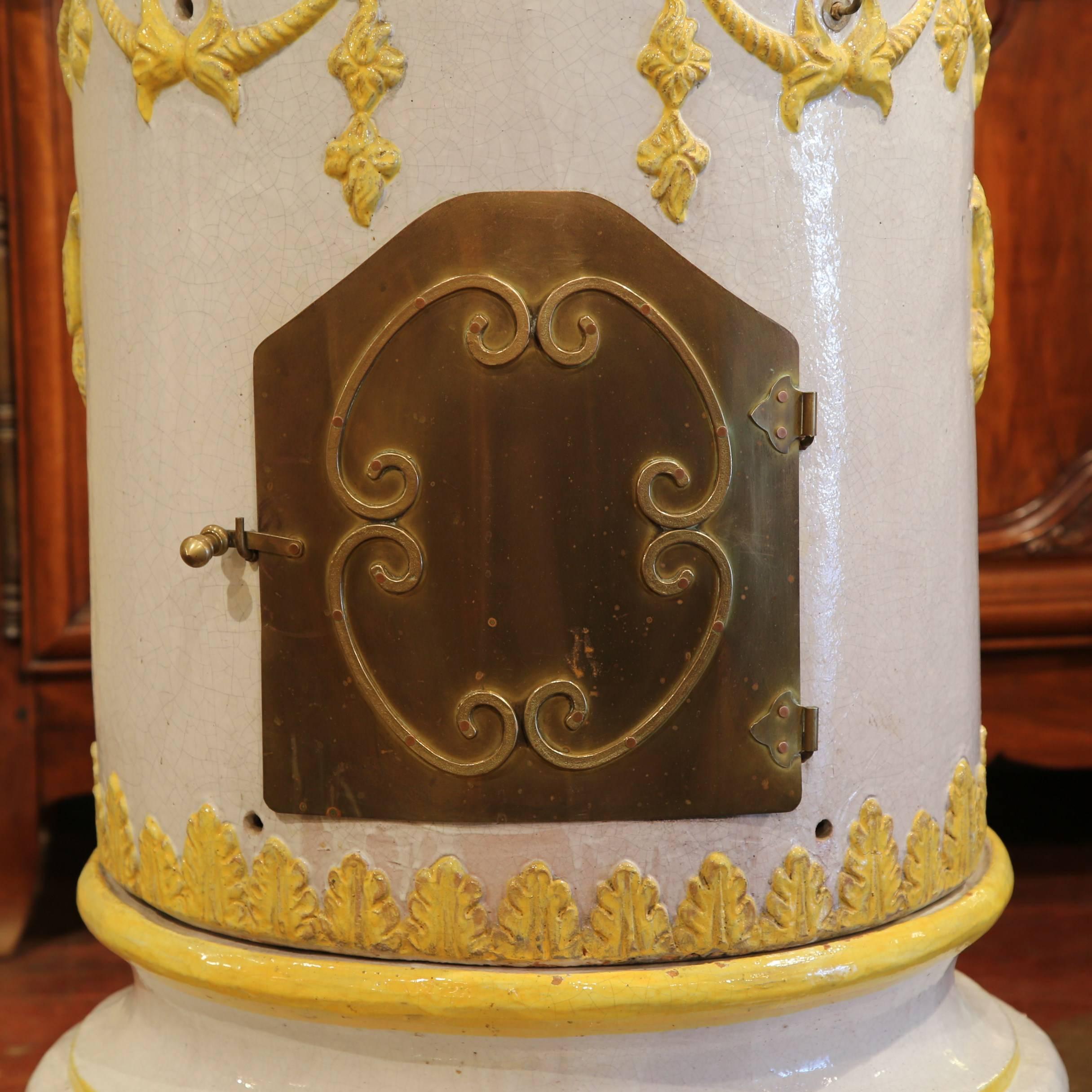 This tall, antique stove was created in Lyon, France, circa 1870. Sited on four bun feet and made in three separate sections, this colorful ceramic piece has a small brass door at the bottom to collect ashes, and a centre door to feed coal or wood