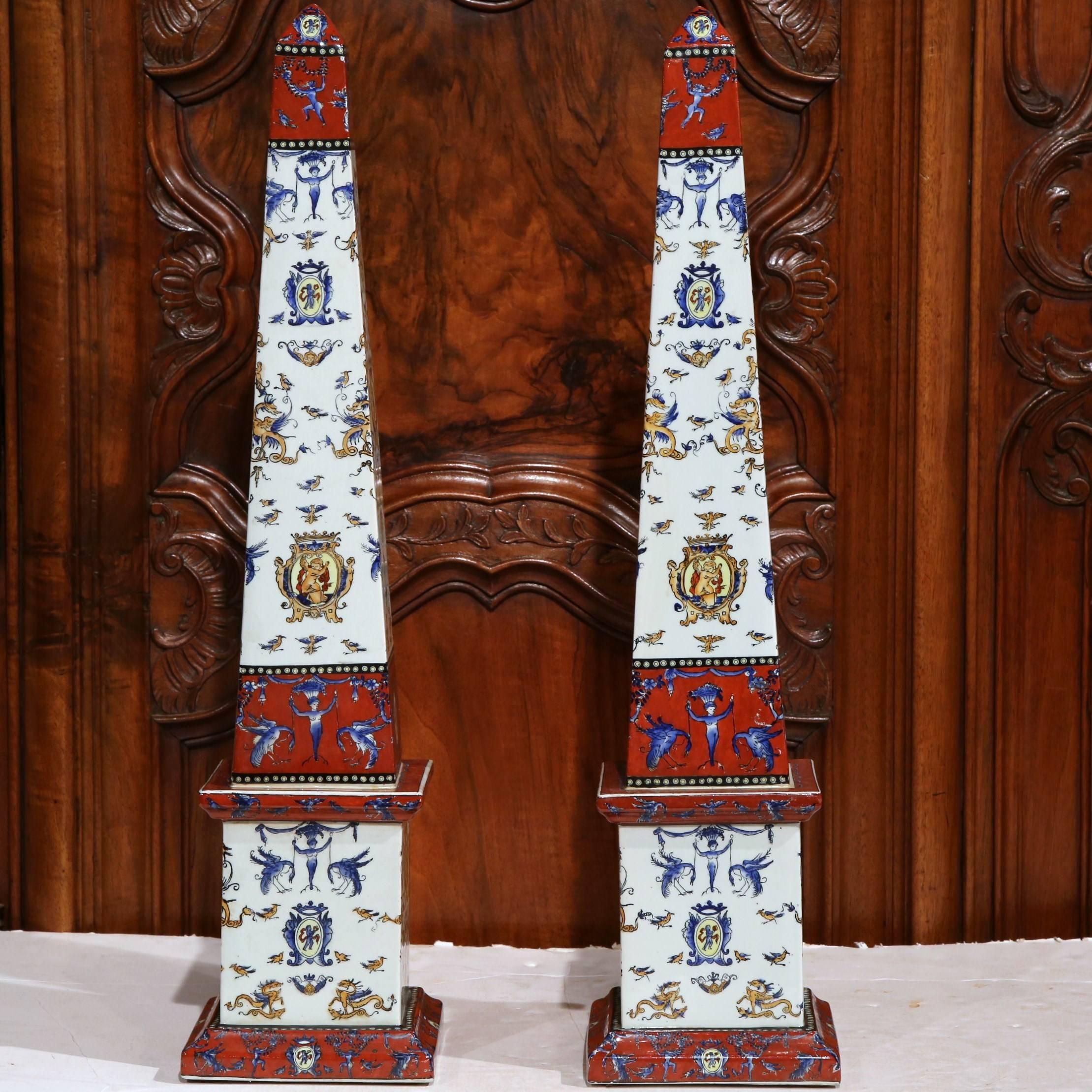 This tall pair of antique obelisks came from “ Faïencerie de Gien”, France, circa 1860. These pieces make a statement with their strong shape and ornate red, white and yellow color palette. Excellent condition with rich old patina.
 The Faïencerie