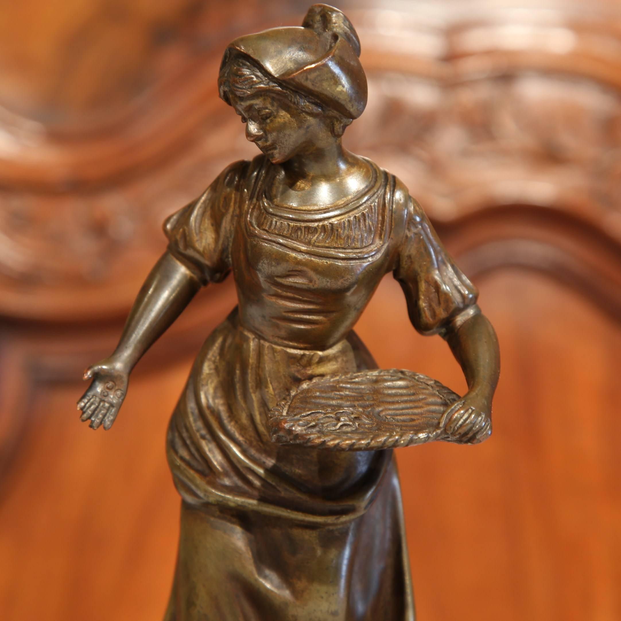 This small bronze sculpture from France was sculpted, circa 1880 and depicts a bucolic scene: A woman feeding a chicken in Provencal attire. The sculpture, mounted on a red marble base, is signed on the back by French sculptor Georges Omerth