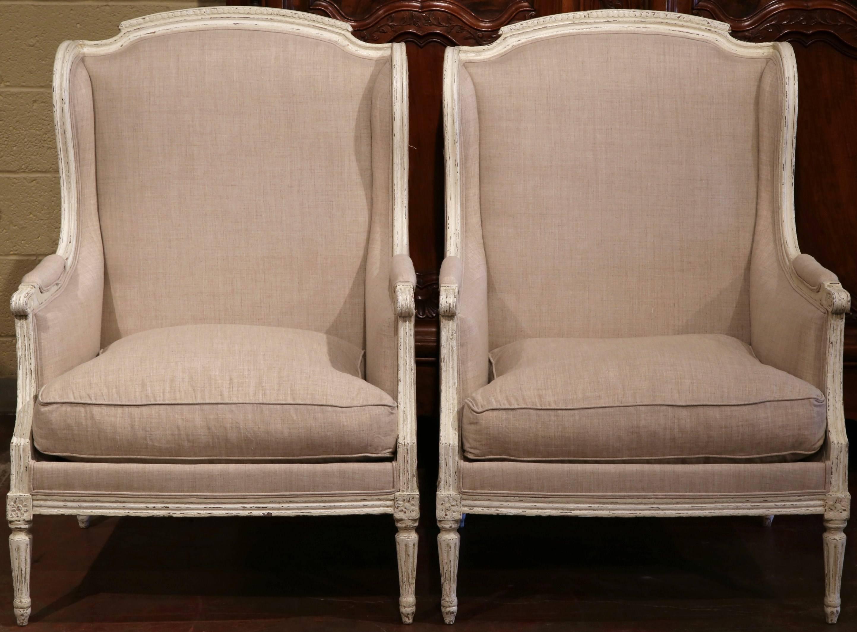 This pair of large, antique fauteuils was created in France, circa 1880. The chairs feature straight lines, tapered legs, and a high, curved back with shaped ears on both sides (fauteuils a oreilles). The armchairs were reupholstered with gray toile