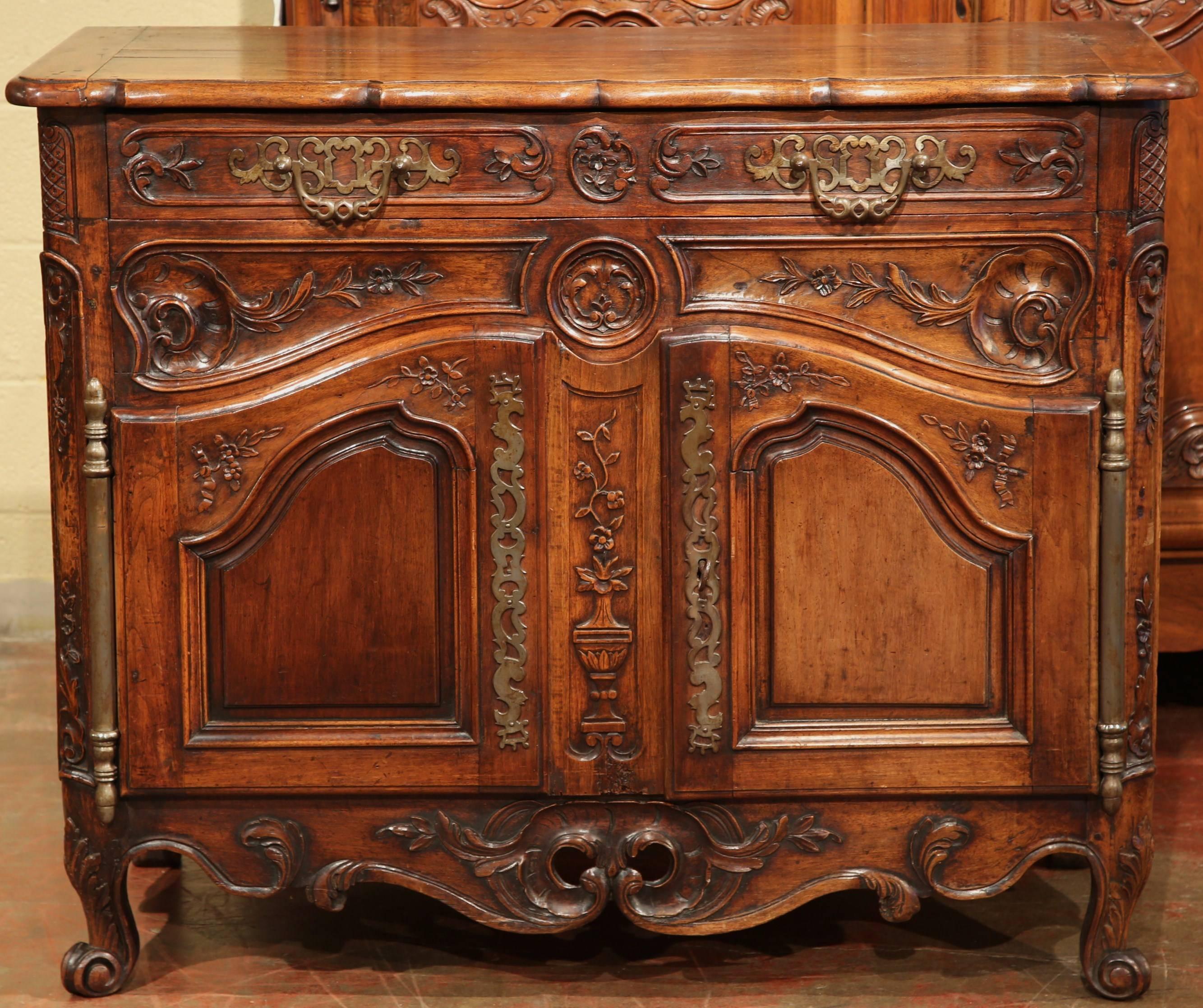 Exquisite antique buffet from Avignon, France, circa 1760. With a large drawer across the front, a pair of carved doors underneath with a carved vase in the center and flowers on the sides, scrolled feet at the bottom with a pierce apron in between.