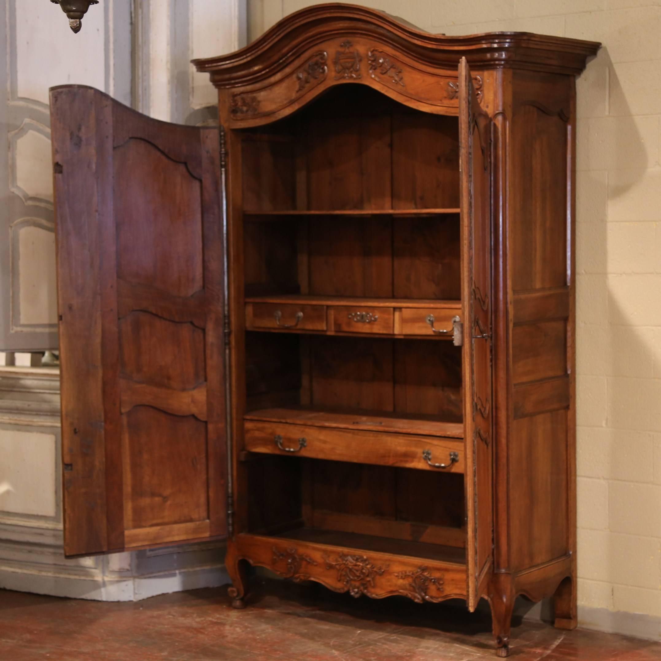 Elegant antique armoire from Arles, France, circa 1780; with exquisite detailed carvings, original pierce hand-forged iron hinges and hardware. Arched bonnet top, paneled and pegged construction. Excellent condition with all the original shelving,