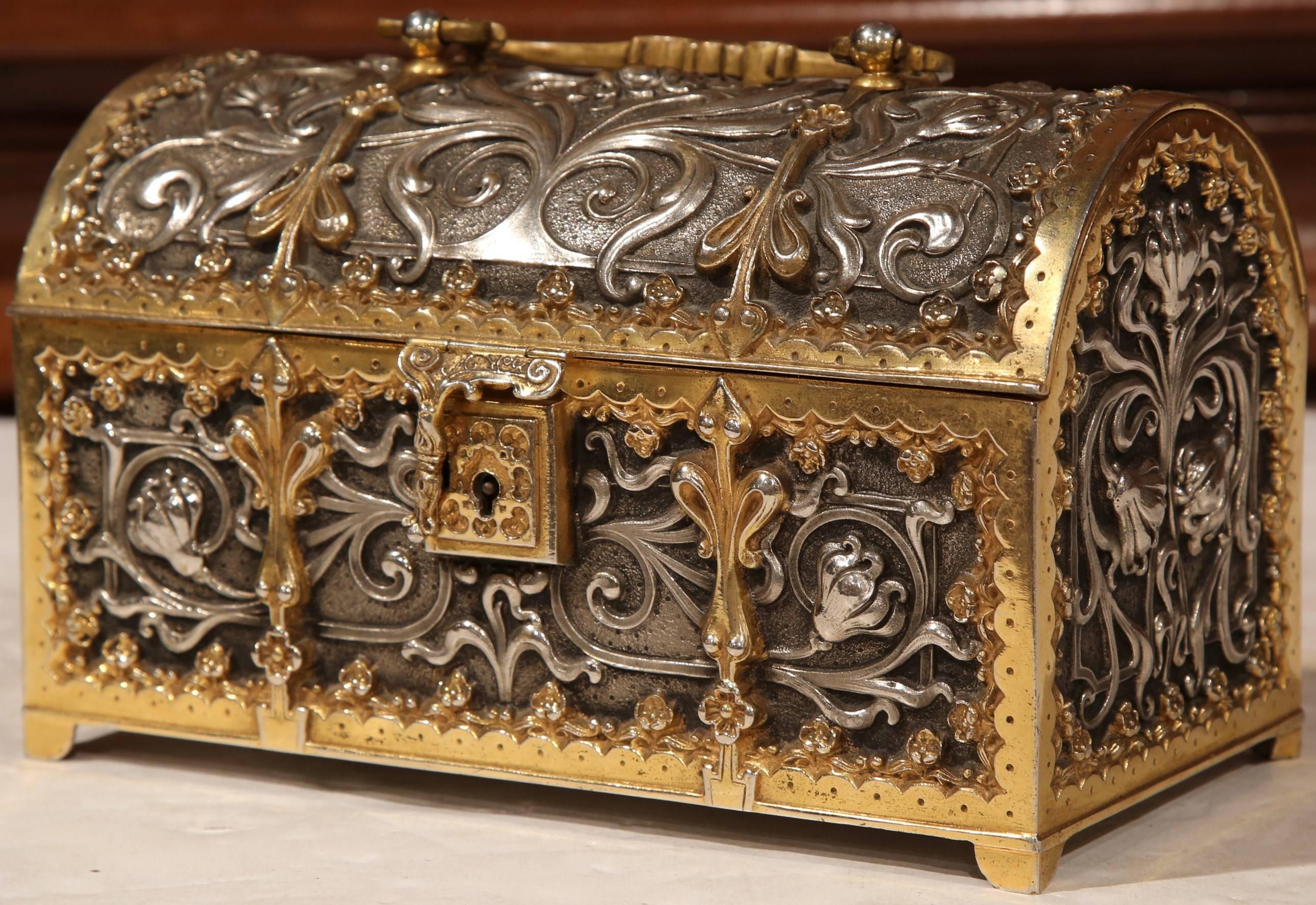 This antique silver and gilt bronze box was created in France, circa 1850. The trunk-shaped box features intricate work on all four sides, a bombe top with handle. The metallic silver and gold, two-toned decorative box includes its original red