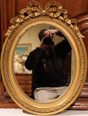Pair of 19th Century French Louis XVI Oval Gilt Mirrors with Carved Ribbon Bow