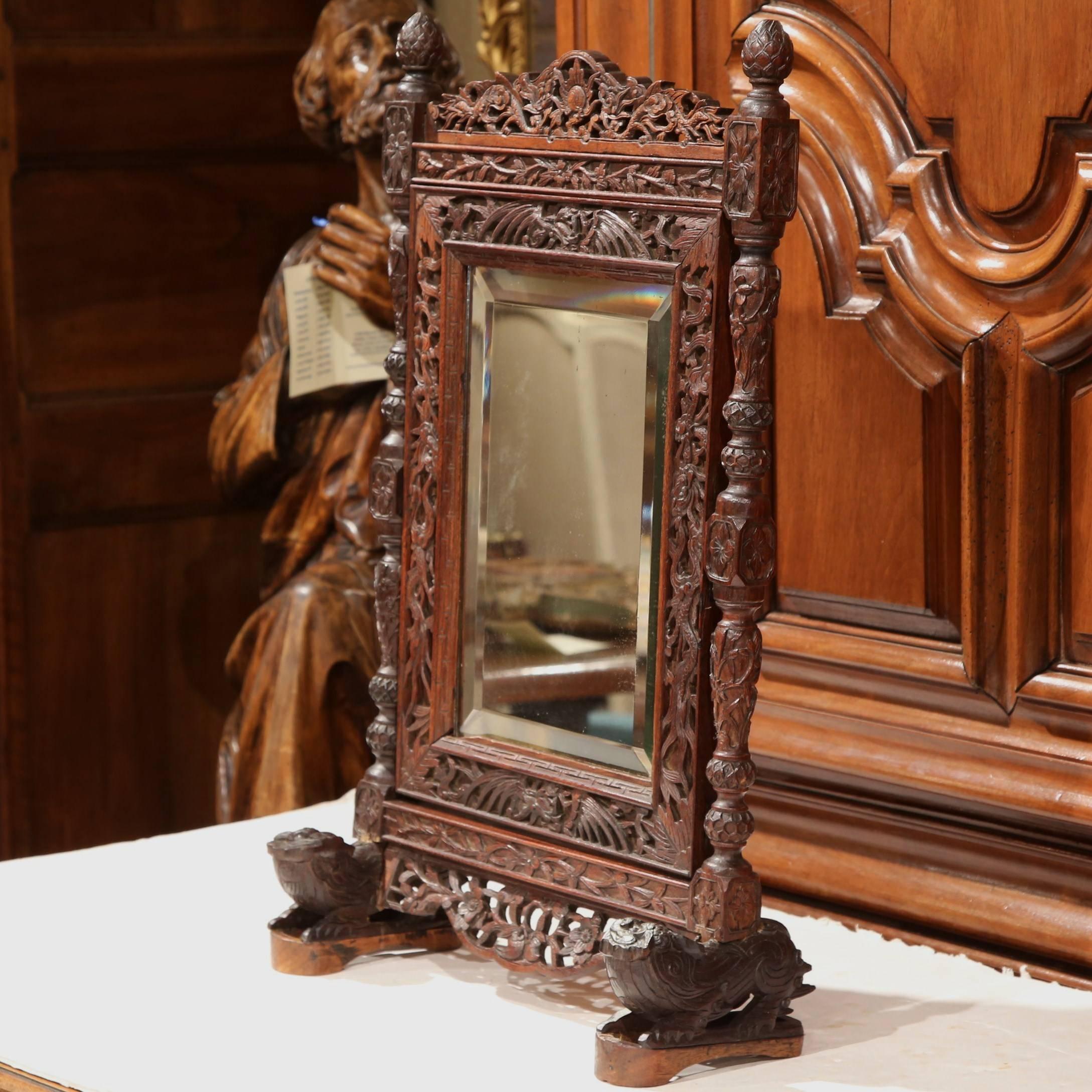 Decorate a counter with this elegant antique makeup mirror frame from the Alps of France. Crafted, circa 1860, the rectangular, tilt-top mirror with beveled glass sits on two pedestal legs and features Fine, intricate floral and foliage carvings