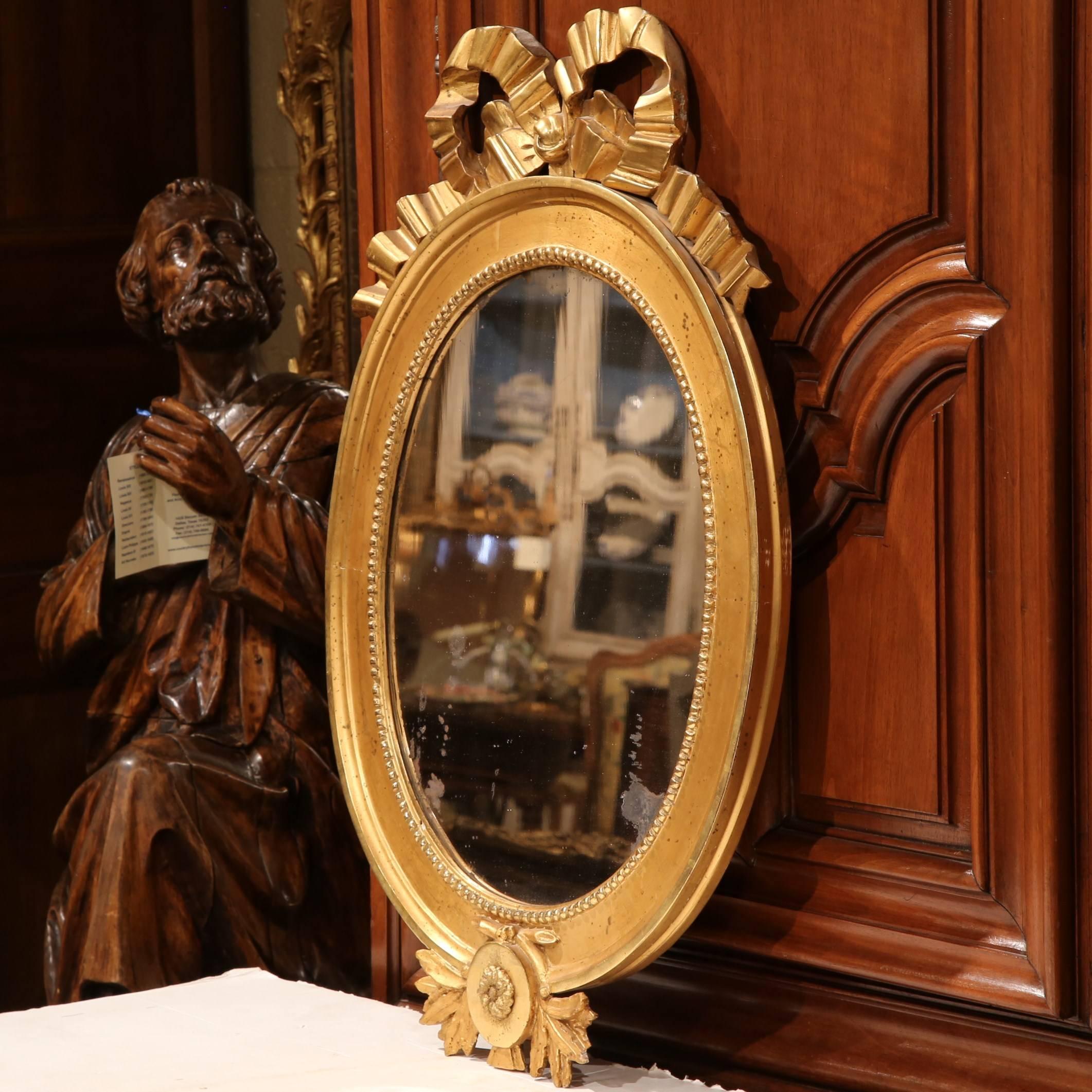 Delicate and beautiful, this oval mirror would make a wonderful addition to a home of any style. Crafted in France, circa 1780, the antique mirror still has its original glass mirror. On the frame of the mirror is an intricately carved medallion,