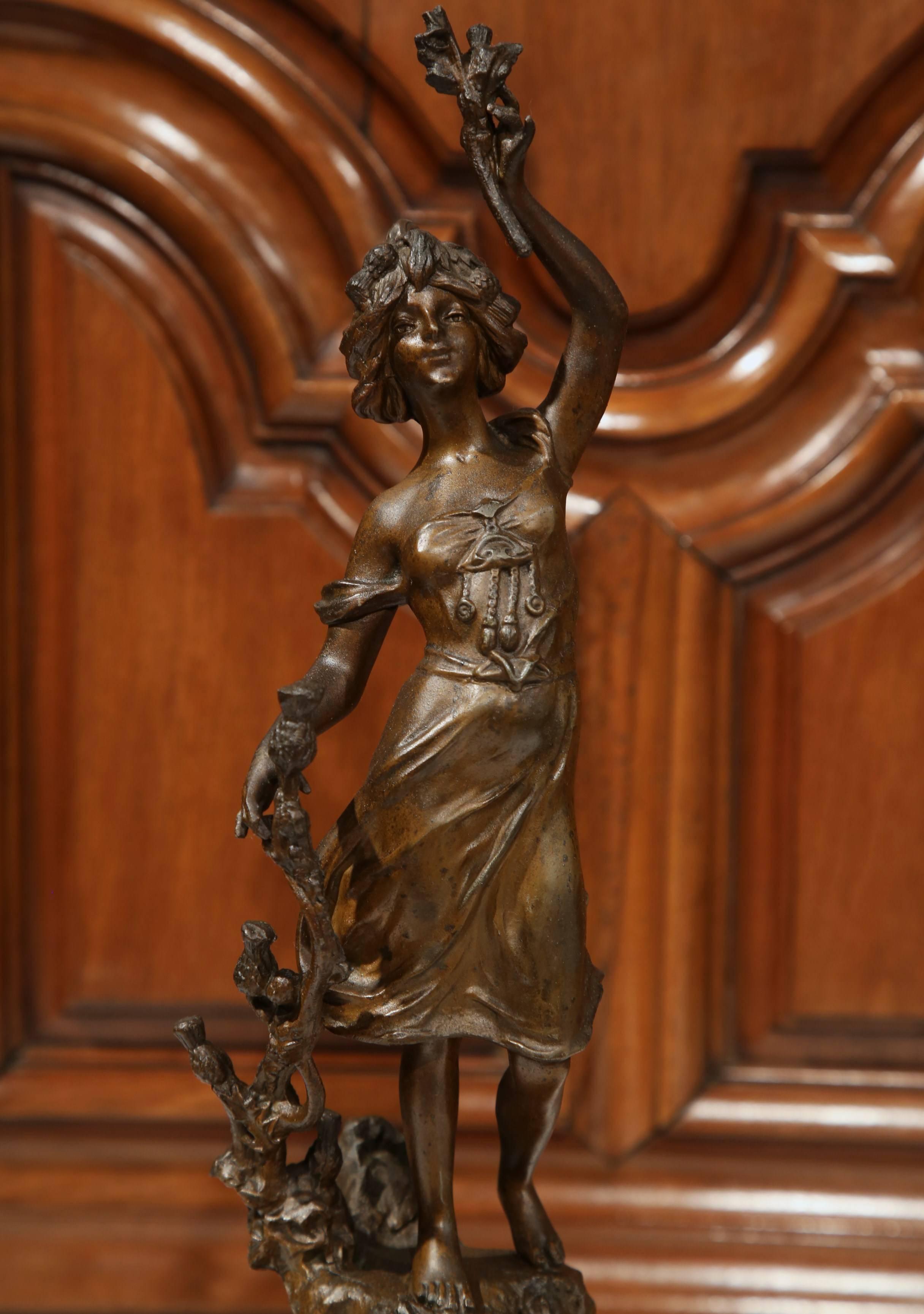 Keep time elegantly with this antique clock from France, circa 1890. The clock is in complete working condition with a pendulum, key, scrolled bronze feet and a flawless porcelain dial. On top of the clock is a sculpture of a young woman holding a