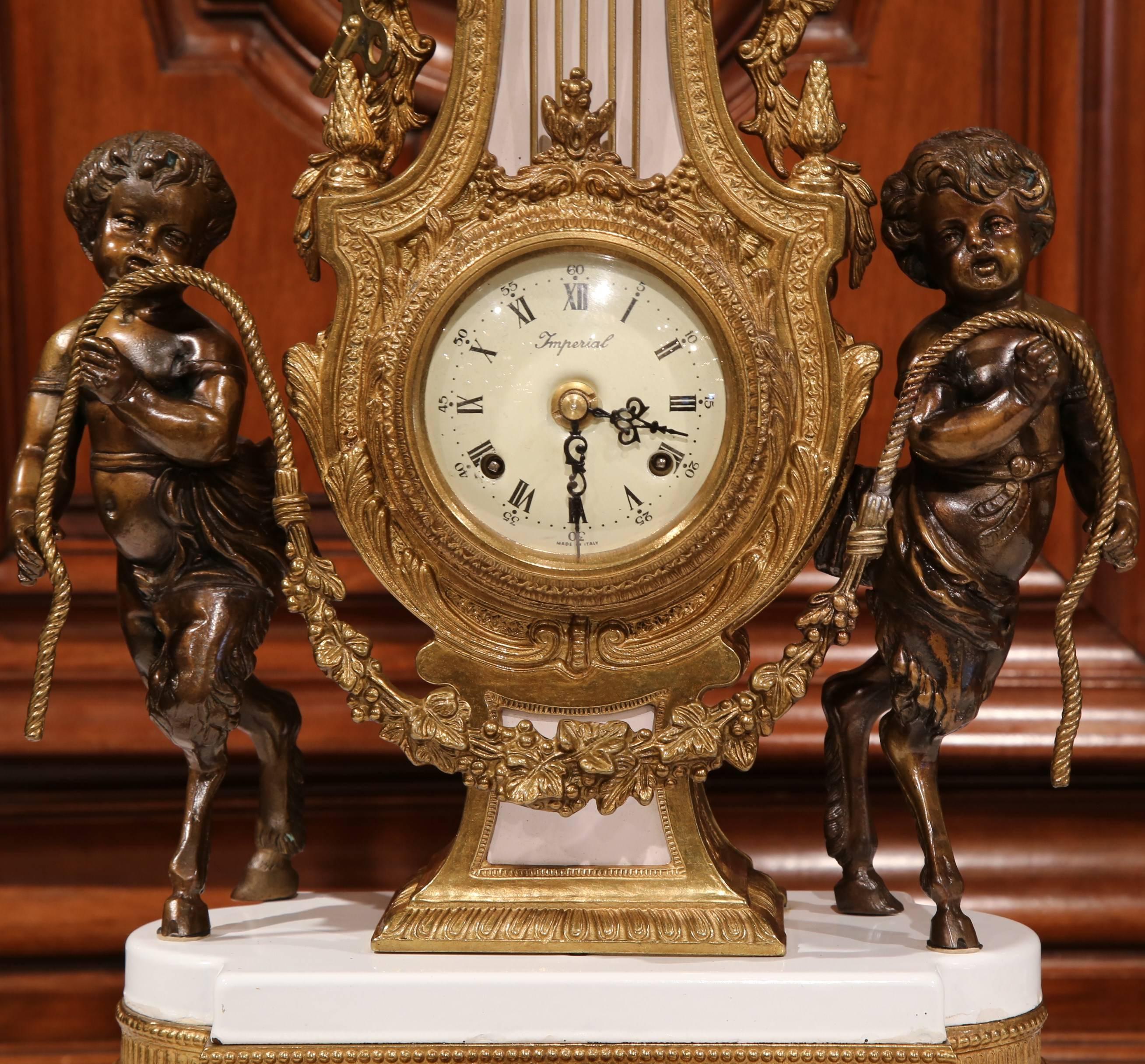 Fine quality bronze mantel or desk clock from Italy, depicting a pair of cherubs on either side of the clock holding a rope. The heavily carved clock with a dial marked Paris, seats on a white marble and an intricate bronze base with decorative