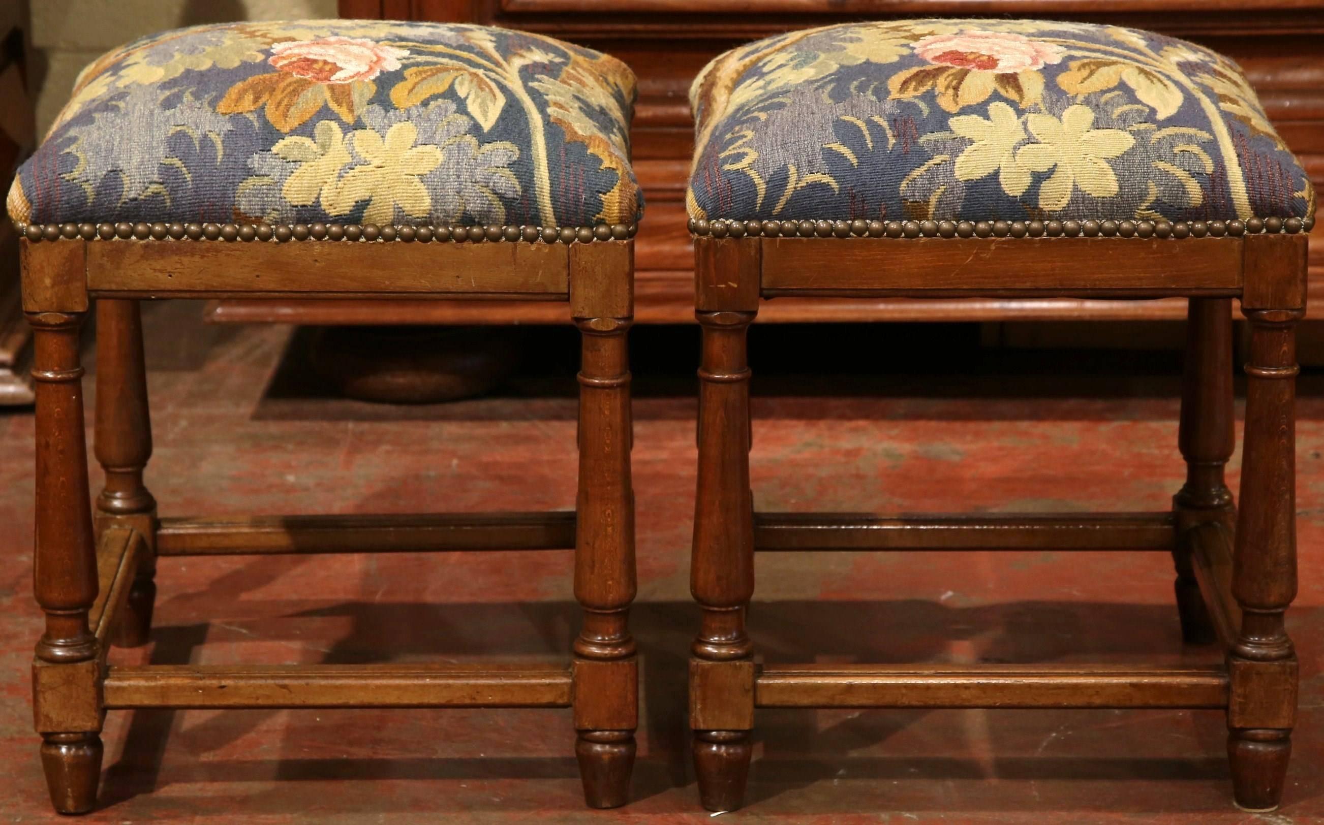 Complete your formal living room with this elegant pair of antique stools from France, circa 1840. Upholstered with a colorful, handwoven 19th century verdure Aubusson tapestry, these stools complement a variety of styles from traditional to