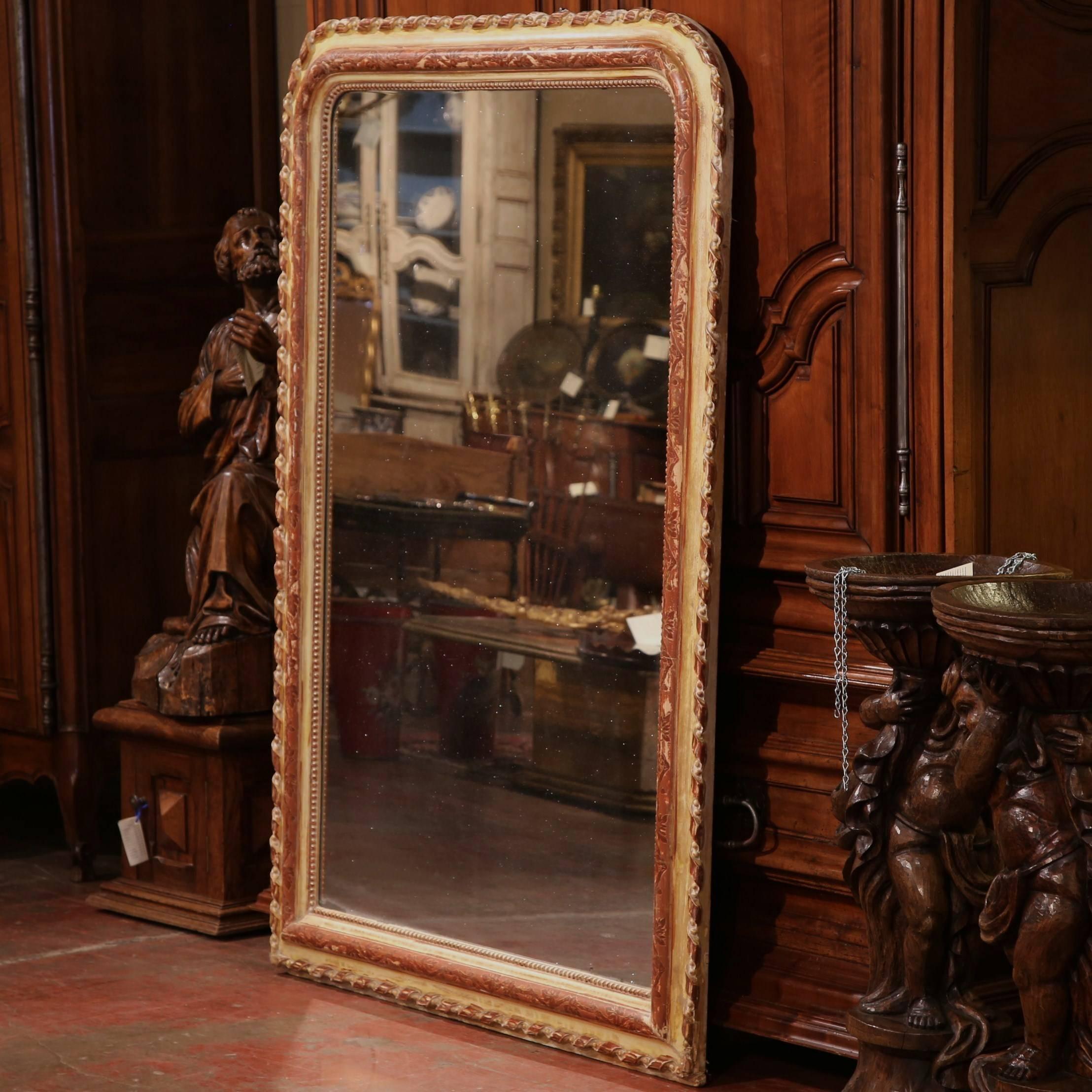 Tall in size and with a unique, beautifully carved frame, this mirror is both functional and stylish. Crafted in France, circa 1850, this Louis Philippe mirror is finished with polychrome, gesso, red and gilt. Get ready in ease by placing this
