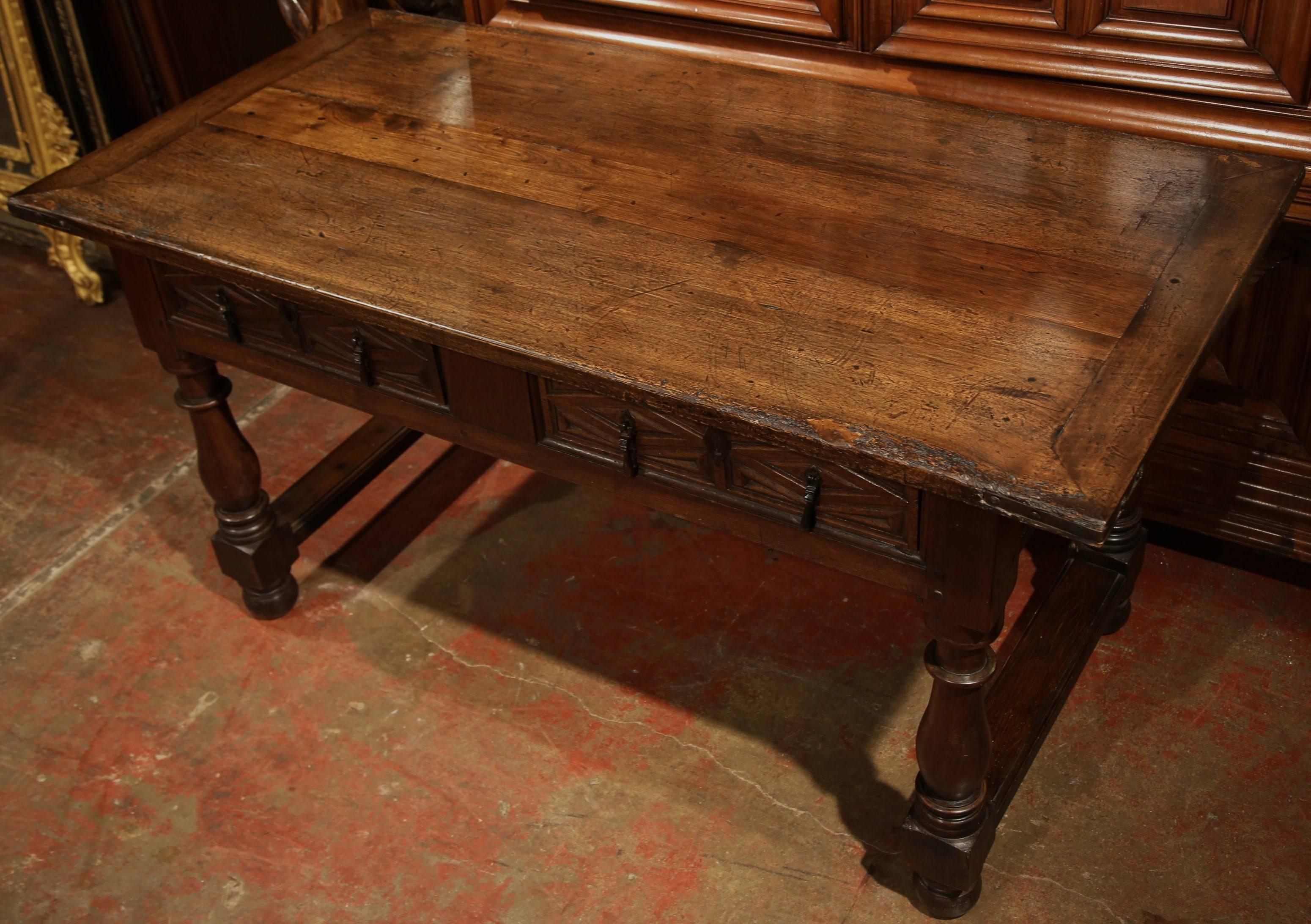 Incorporate more surface space into a long hallway or entryway with this elegant antique fruitwood console from Spain. Carved circa 1780, the table features a rectangular surface area, two drawers and turned legs joined by a bottom stretcher. The
