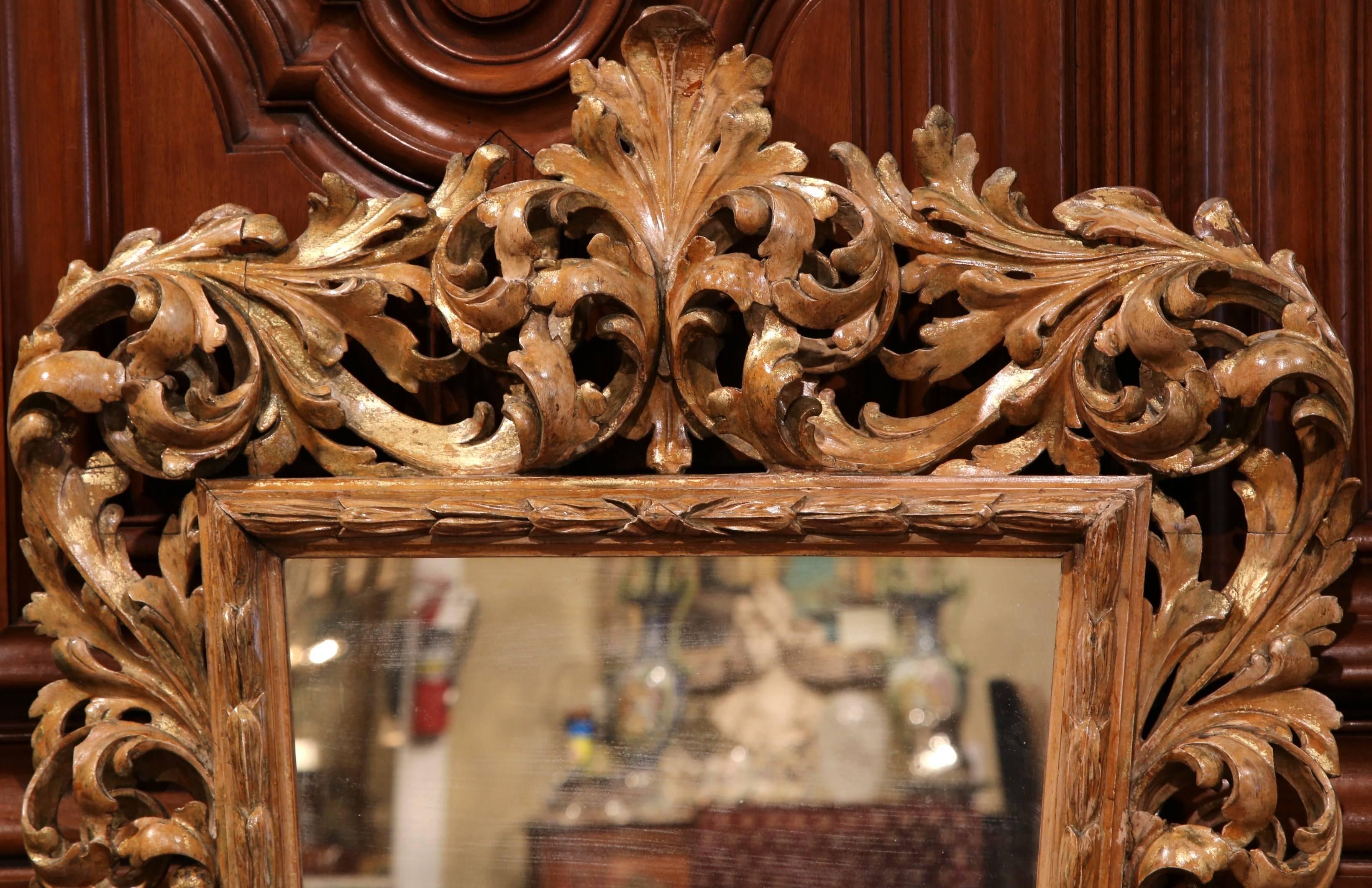 Decorate a powder room or entryway with this Old World elegant antique carved mirror. Crafted in southwest France, circa 1850, the long and fluted mirror is set inside of an intricately carved frame; it is decorated with hand carved scrolled foliage