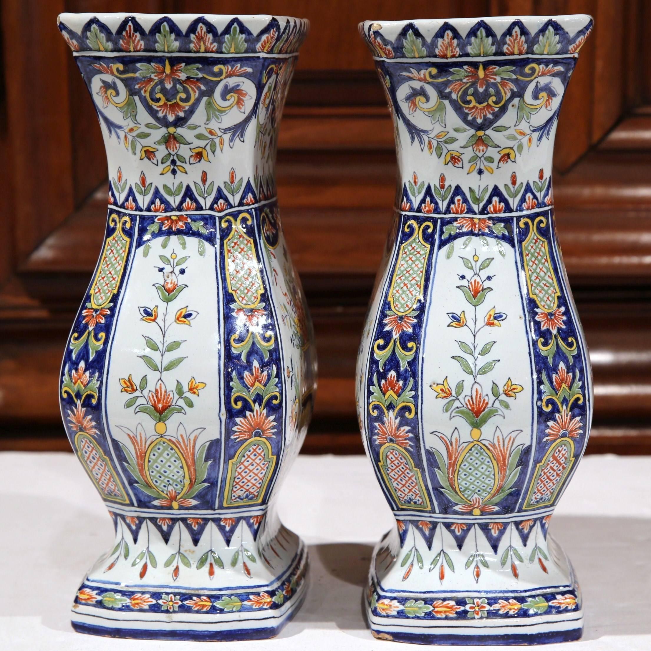 Add color to a living room or dining room with this fine pair of antique vases from Rouen (Normandy), France; crafted circa 1870, both vases are intricately hand-painted with beautiful floral motifs. The colorful vases have a wide mouth and would