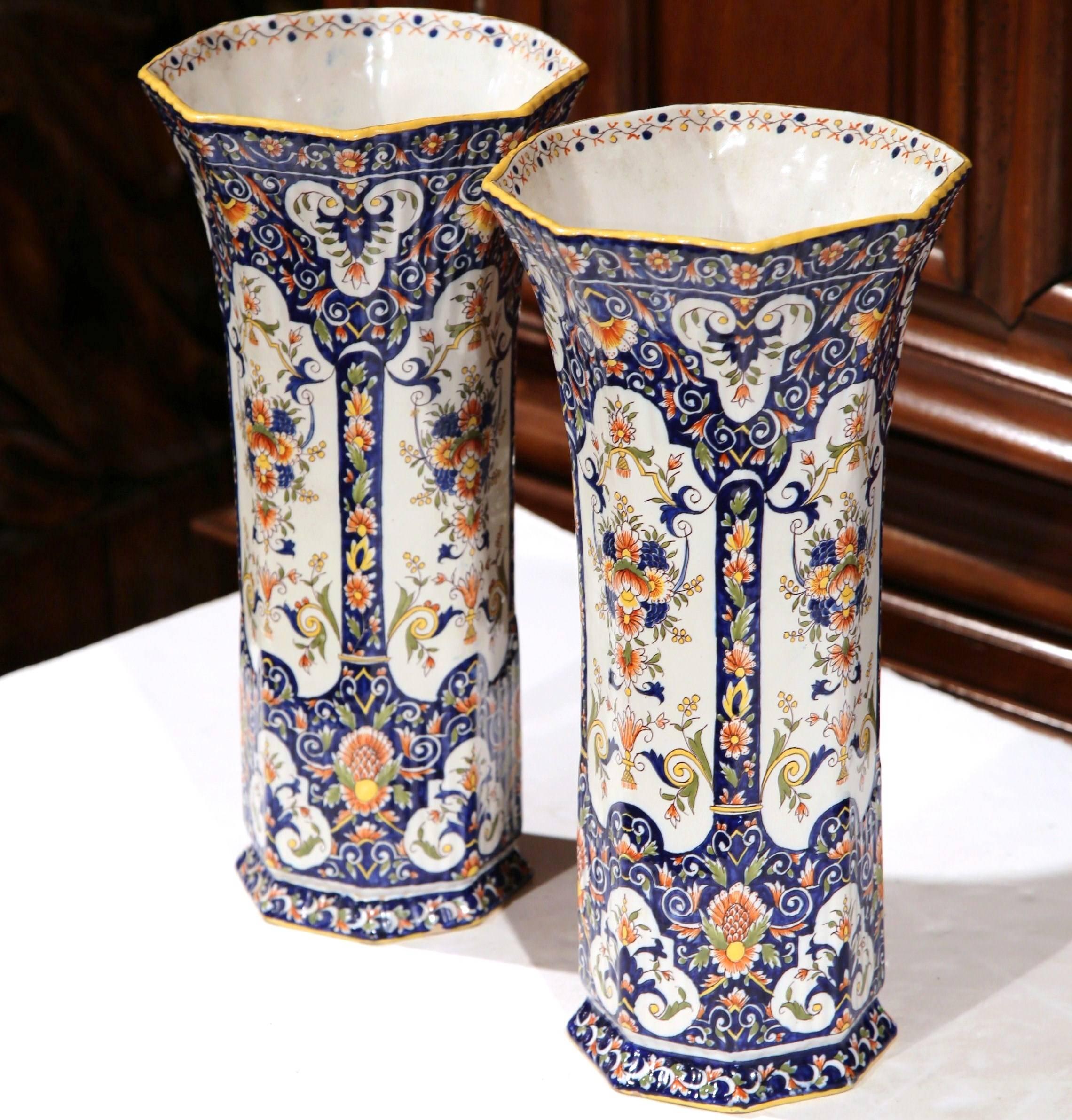 Incorporate beauty and color into your home with this elegant pair of antique ceramic vases, crafted in Rouen, France, circa 1860, the tall colorful vessels feature a circular bottom and a wide mouth at the top with floral motifs. Both vases are in
