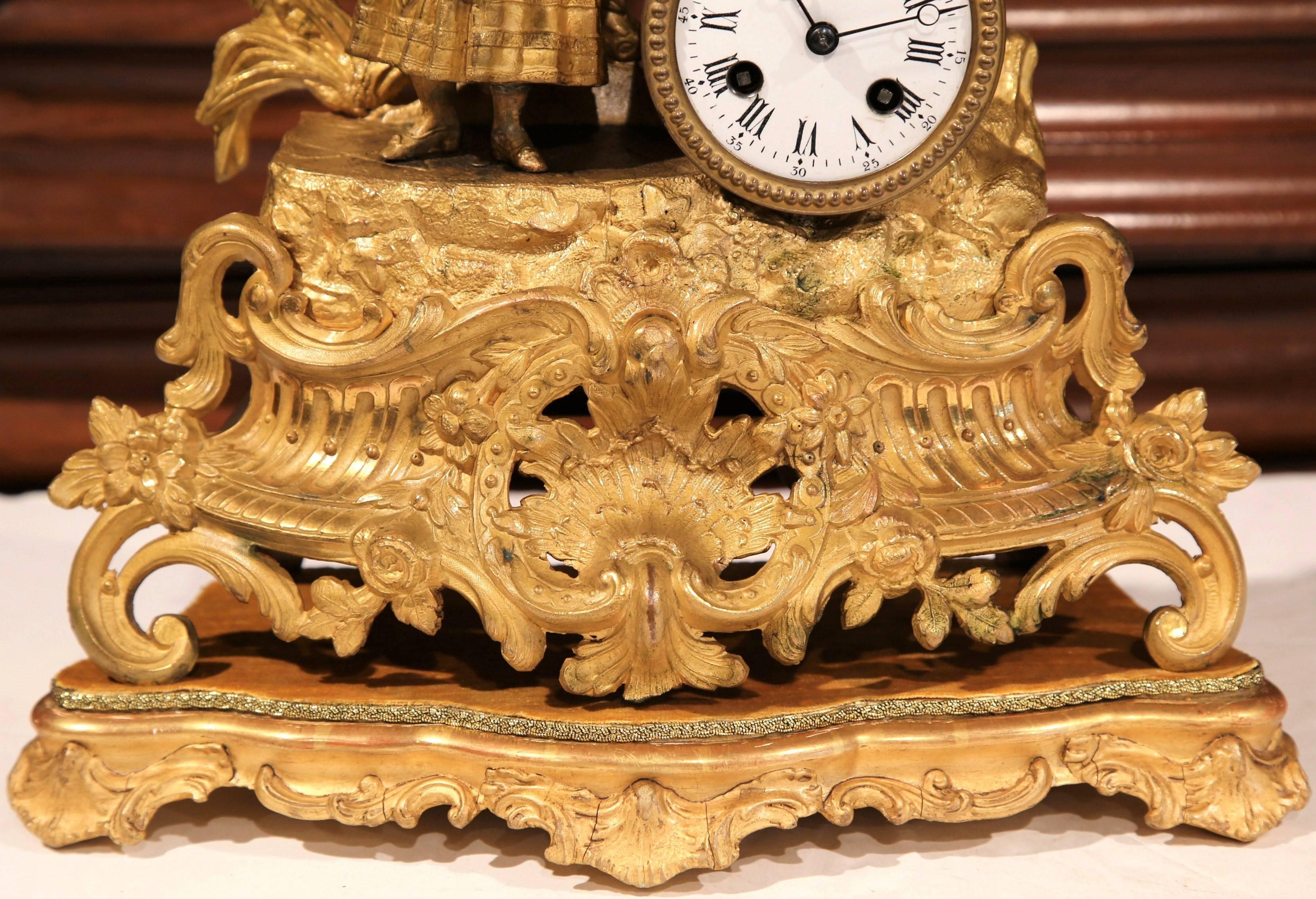 Add extra elegance to your mantle or desk with this gold plated mantel clock. Created in France, circa 1860, the working, asymmetrical clock features a peasant woman carrying a basket of fruits and a jug of water on her shoulders. There is Intricate