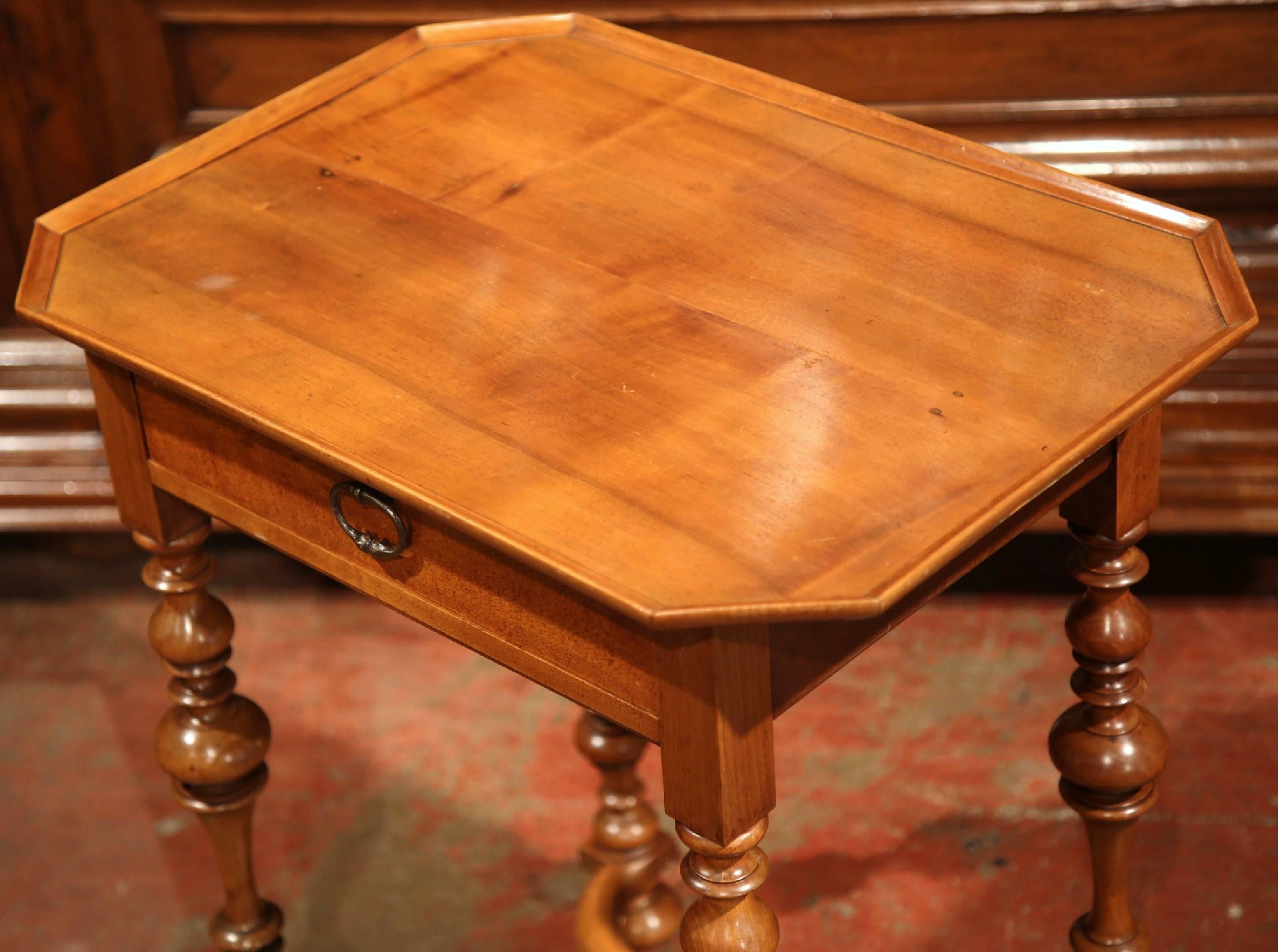 This elegant, small antique fruitwood end table was created in Southern France, circa 1880. This table features four turned legs with a X-stretcher and a carved centre finial. Across the front is a single drawer with an iron handle. The table is