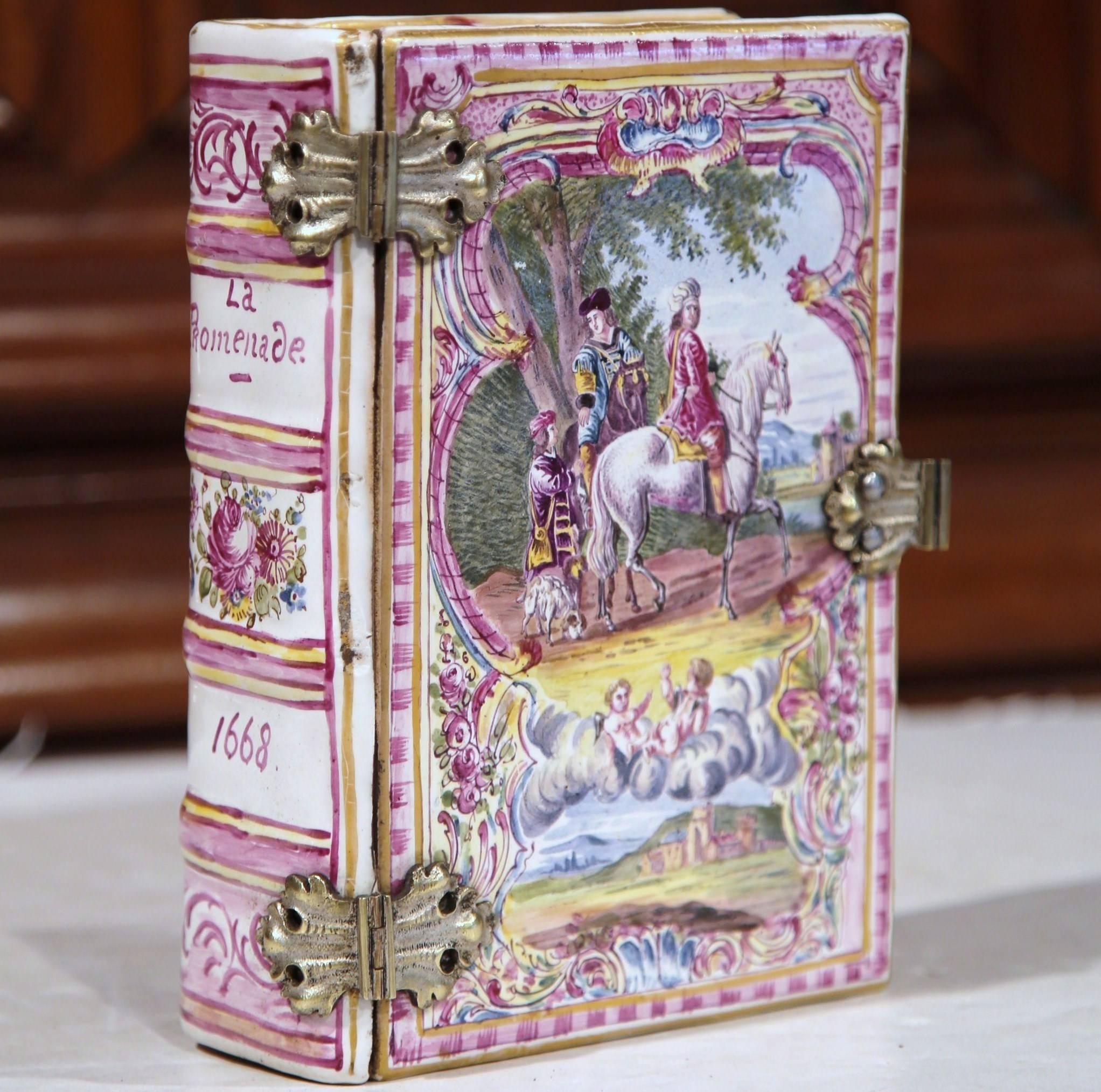 This unique antique decorative porcelain box was sculpted in Paris, circa 1840. The ceramic book is called La Promenade and dated 1668 on the spine. The outside of the jewelry box features exquisite painted Renaissance figures, scenes and landscapes