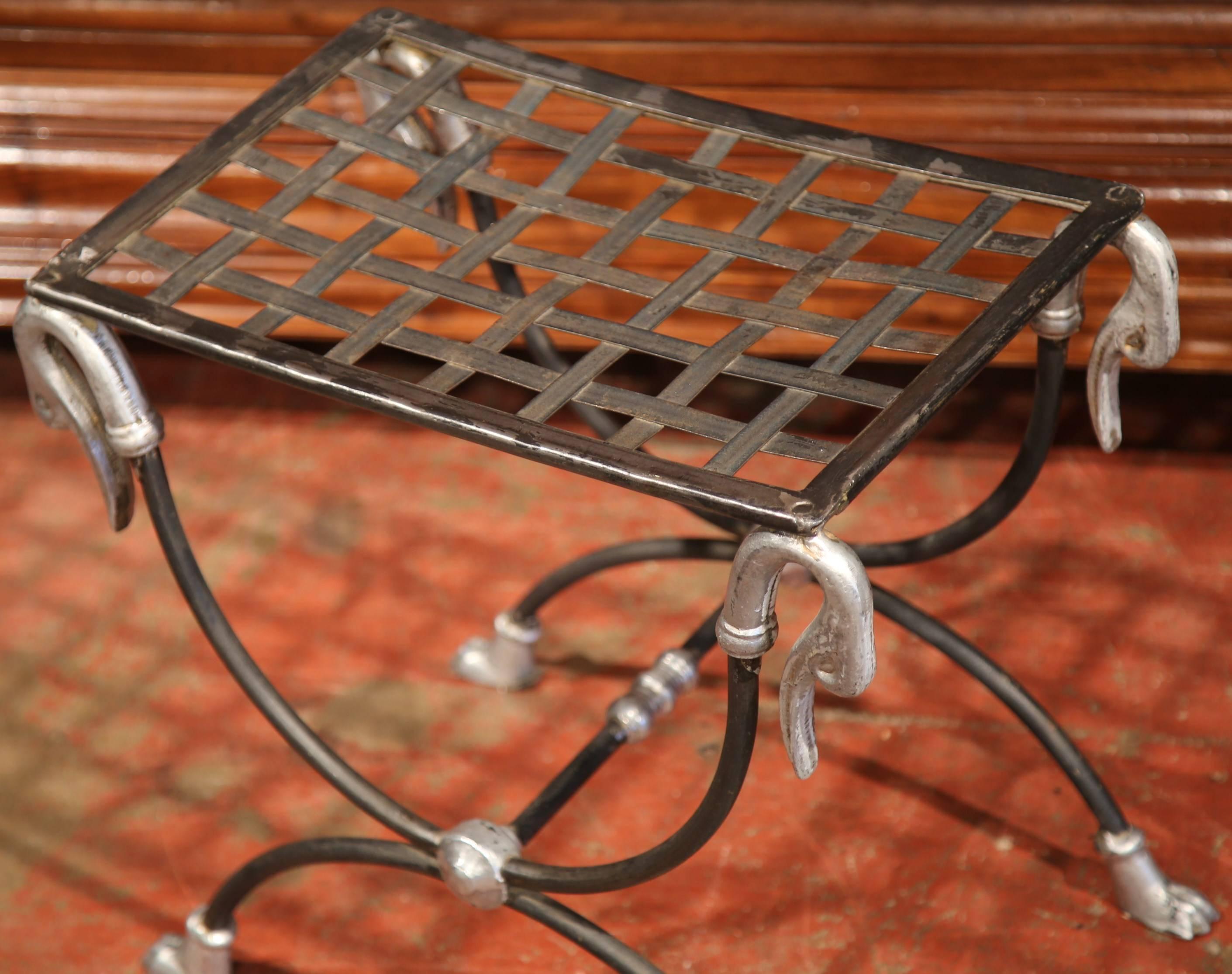 Add elegance to your bathroom with this interesting iron forged vanity stool from France, circa 1920. Created in the Dagobert style, the stool has a geometric weave design seat, which is held up in the corners by four swan faces and paw feet at the