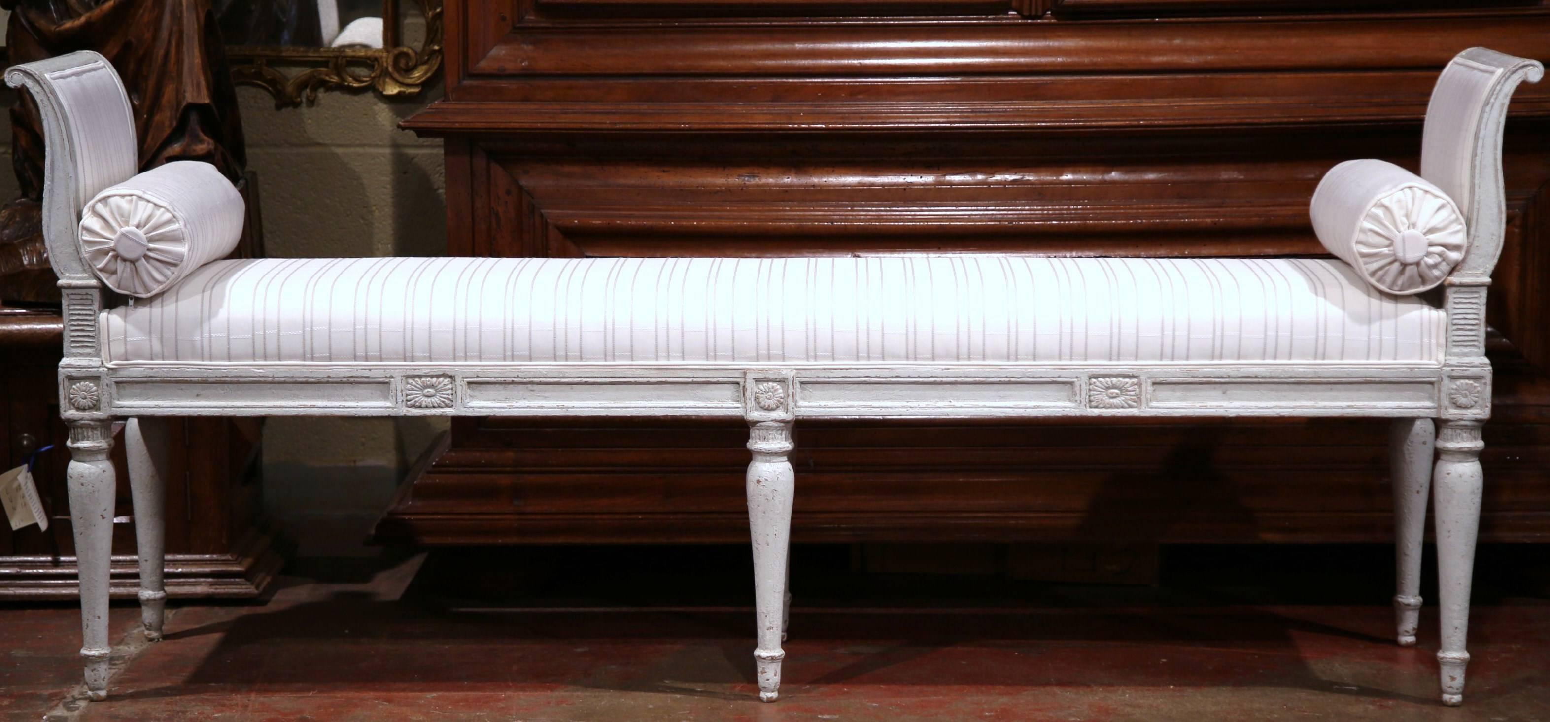This elegant, antique banquette was crafted in France, circa 1880. The long and narrow bench features six turned and tapered legs, a curved back at each end and hand carved medallion motifs around the apron. The seat has been reupholstered with a