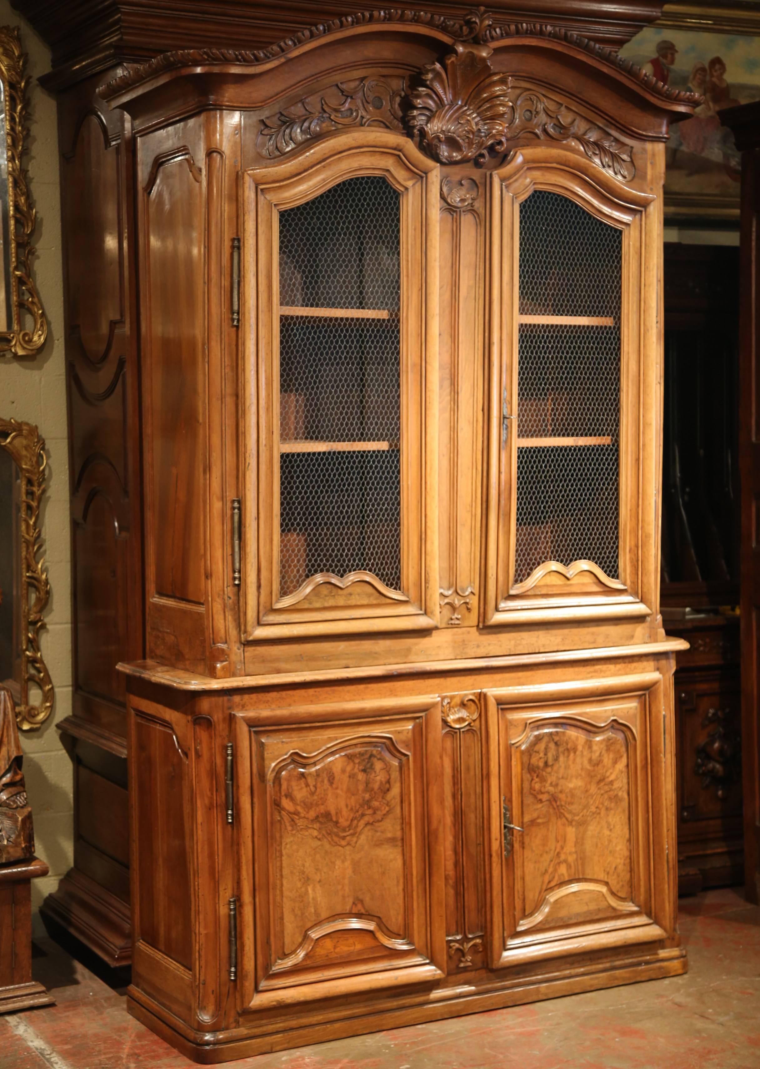 This exceptional, antique fruitwood buffet-deux-corps was carved in Lyon, France, circa 1750. Built in two parts, this tall, elegant cabinet stands on a plinth at the base; it features a 