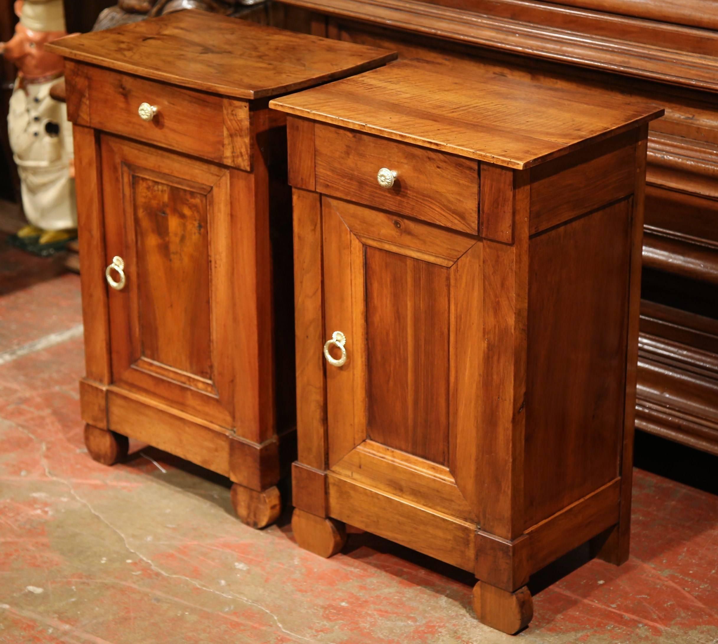 Add surface space in your bedroom with this elegant pair of antique fruitwood nightstands from France. Crafted circa 1890, each of these classic cabinets features a centre drawer with cupboard door underneath. In the traditional Louis Philippe