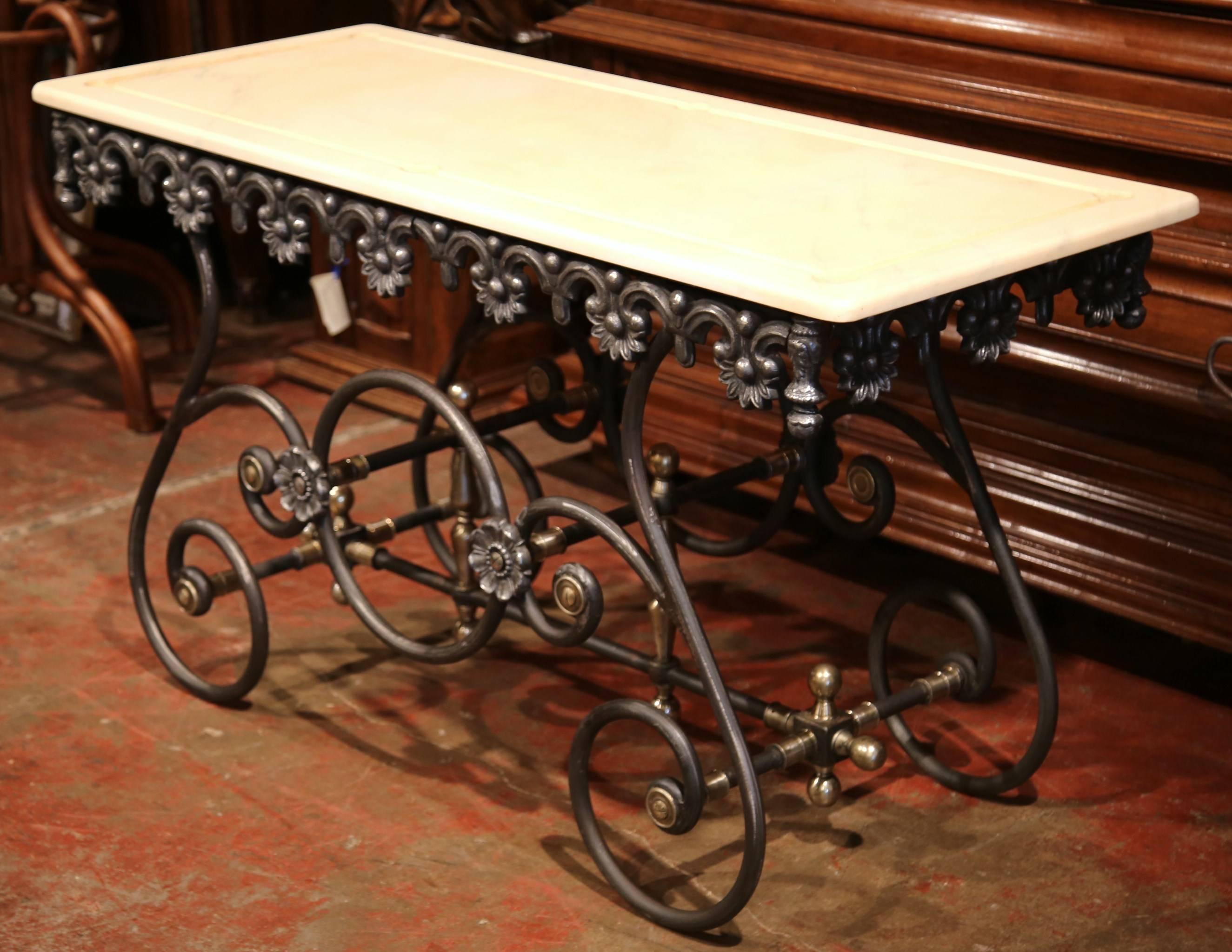 This long, narrow French butcher table (or pastry table) would add the ideal amount of surface space to any kitchen. This table has a polished iron finish and features a scalloped apron with intricate metal work and beautiful scrolled legs. The