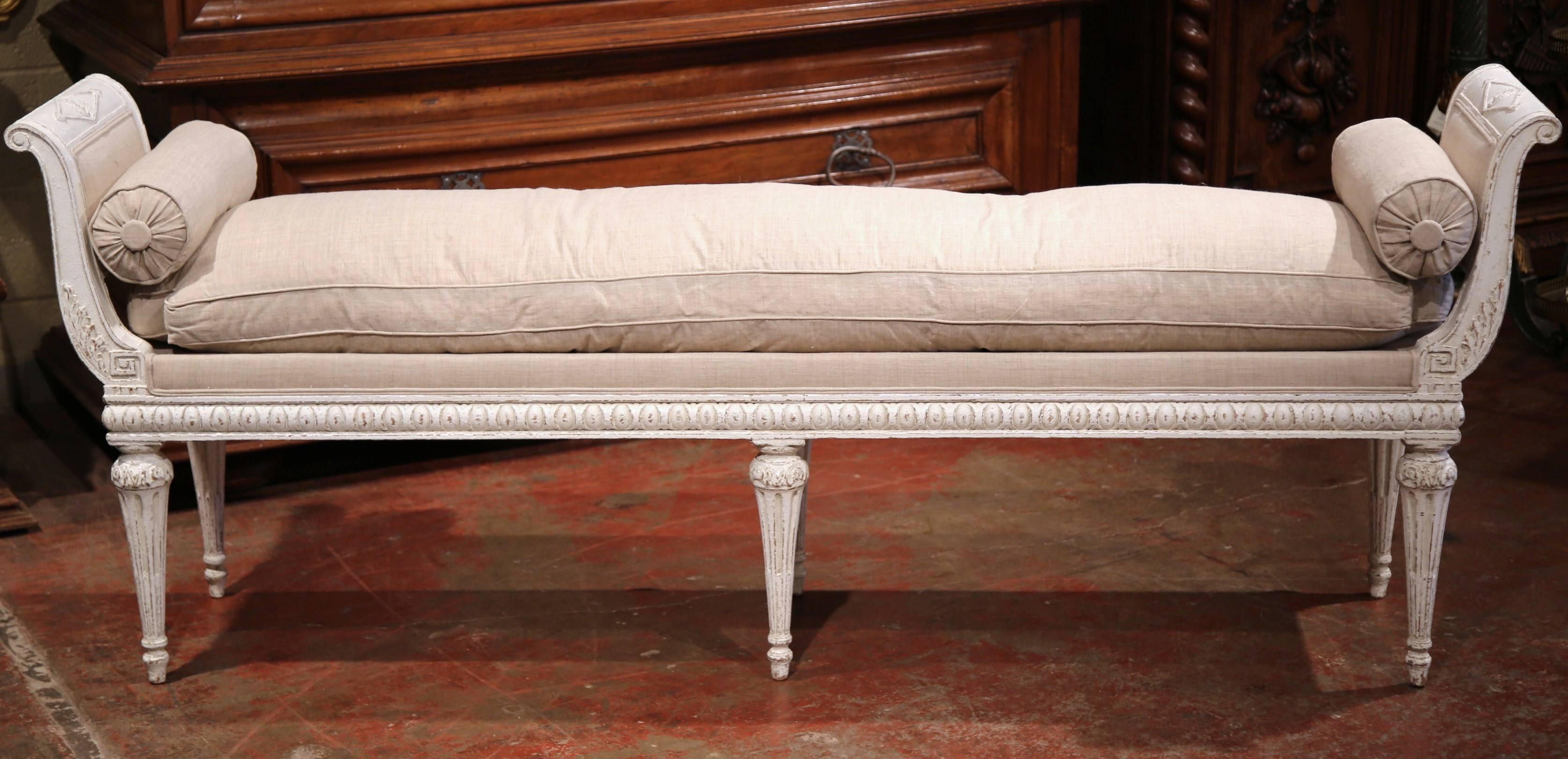 Add extra seating to a living room or the foot of a bed with this elegant, narrow antique banquette from France, circa 1880. The bench has six tapered legs, a carved apron and a curved back at each end in the Empire or Directoire style. The piece