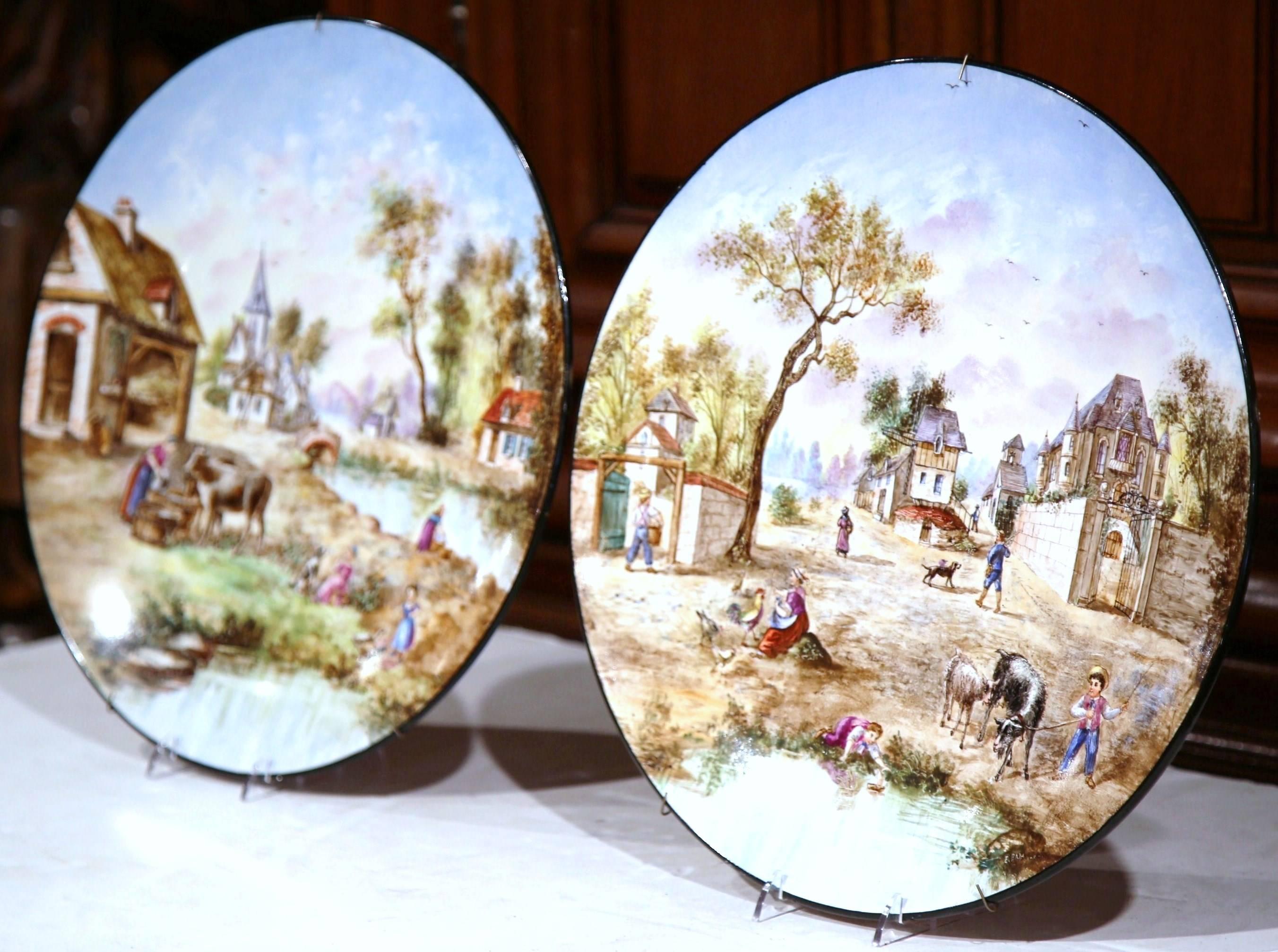 Decorate your kitchen wall with this pair of large, colorful chargers from France. Sculpted, circa 1900, the hand-painted plates are signed 