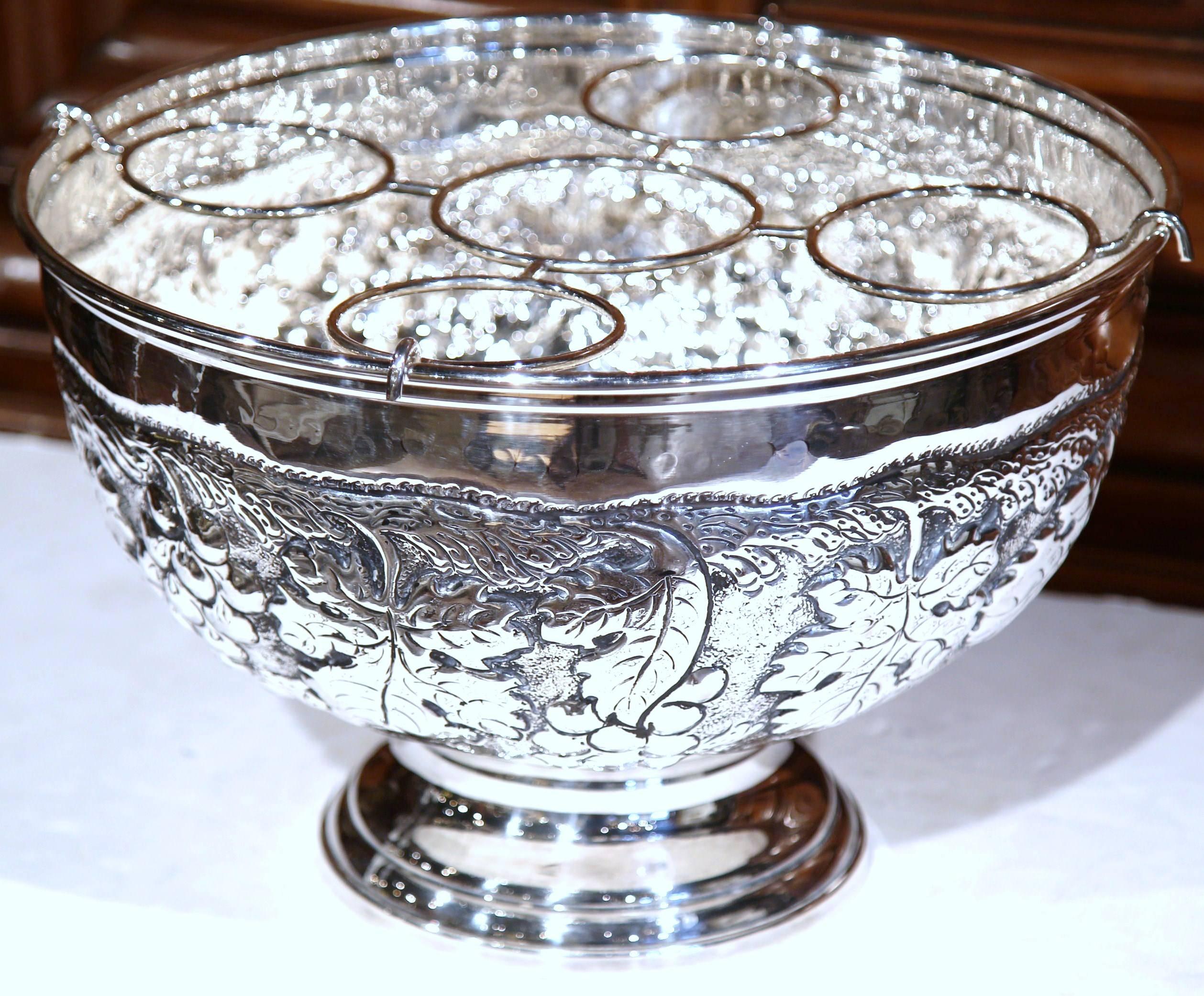 Keep your wine or champagne chilled in style with this elegant round bucket from France. The outside features intricate repousse decorative motifs of grapes and vines. Inside the bucket, two removable trays will hold up to five bottles. This silver