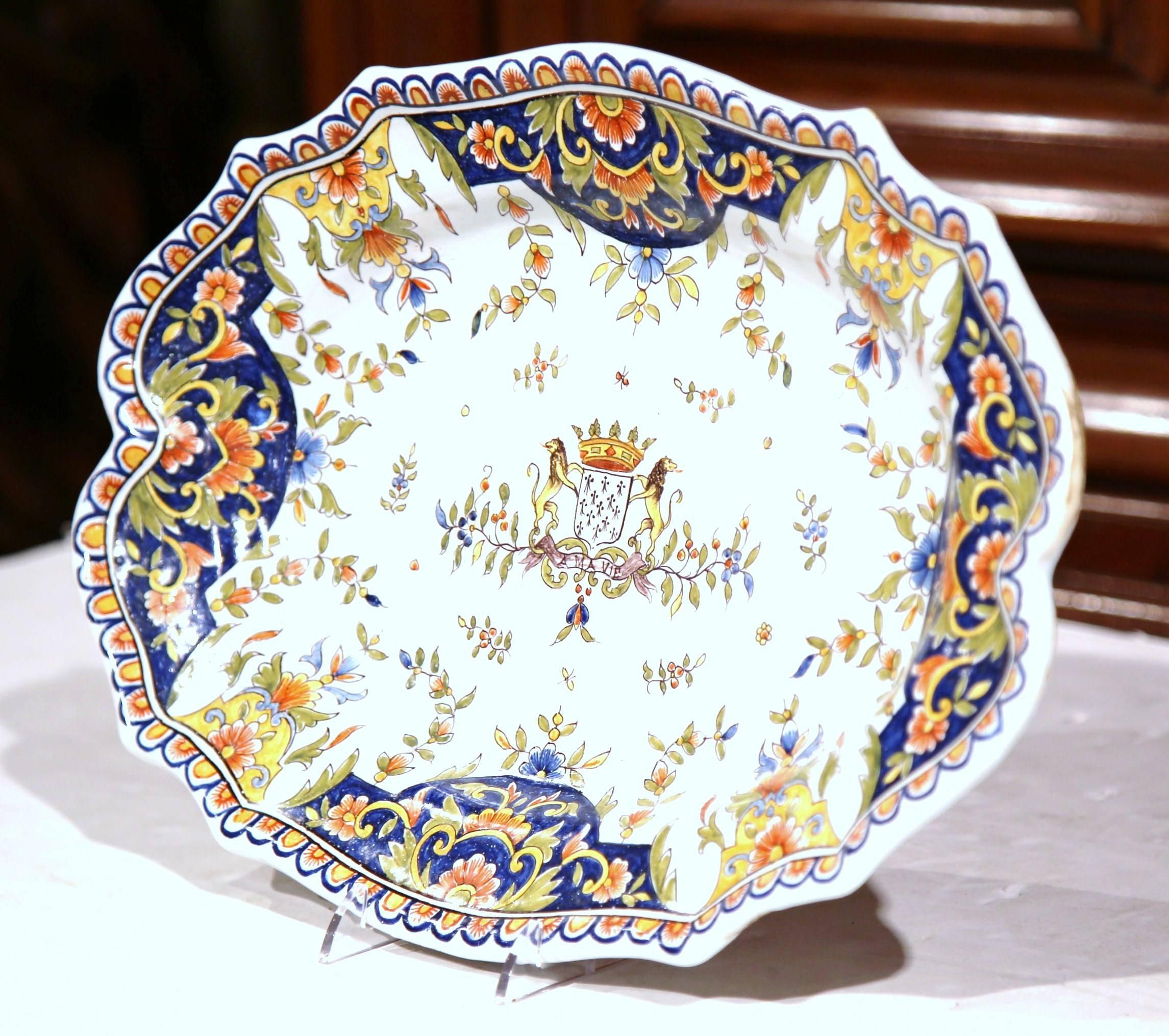 This beautiful antique wall hanging platter was crafted in Rouen, northern France, circa 1870. The colorful, oval dish with floral decor around the periphery, features a traditional center coat of arms with Fleurs-de-Lys and a pair of royal lions
