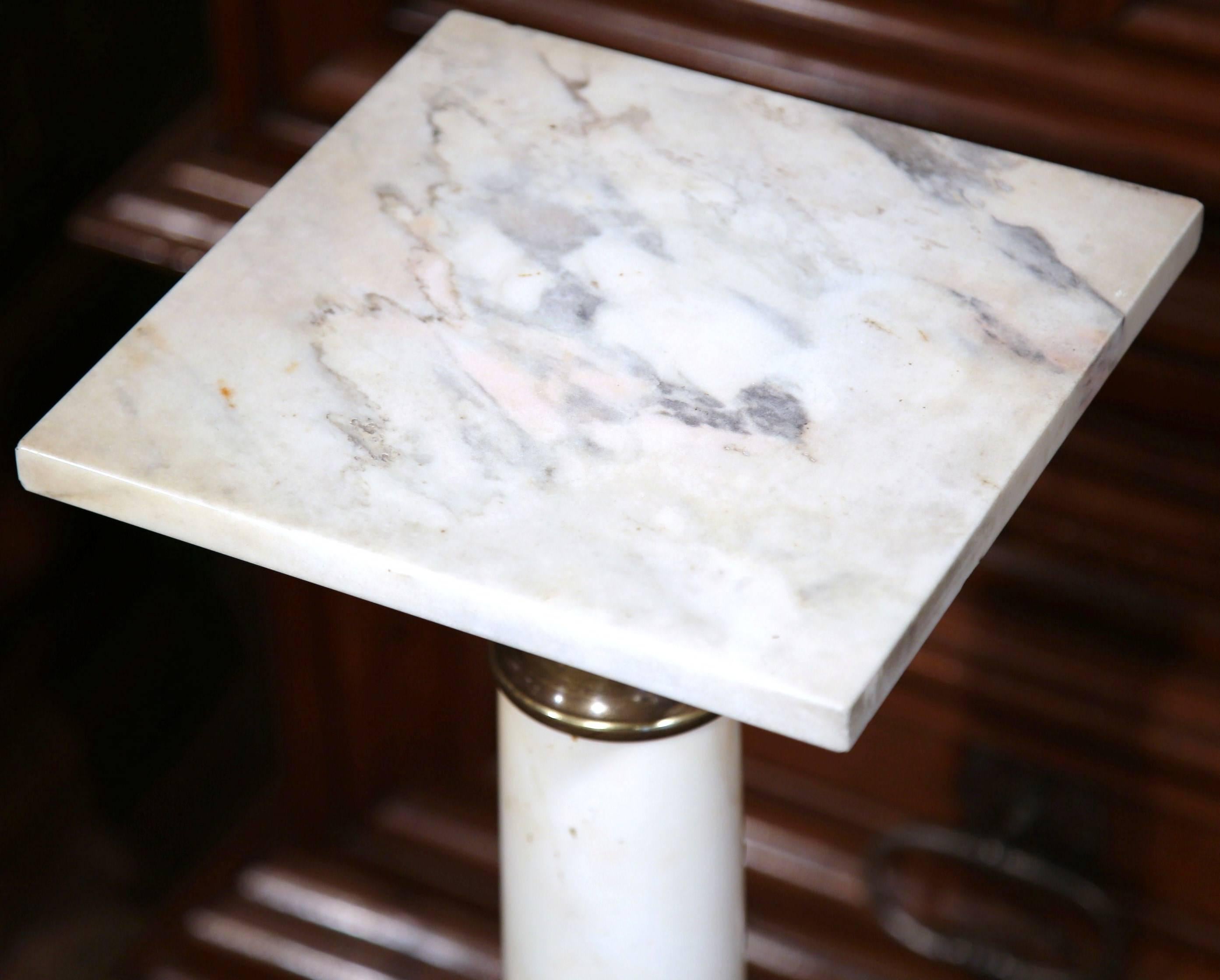 This elegant antique white marble pedestal was crafted in France, circa 1870. The pedestal features a sturdy square base with a repousse brass ring and a square swivel surface with ornate brass mounts. Place this Classic, column pedestal in the