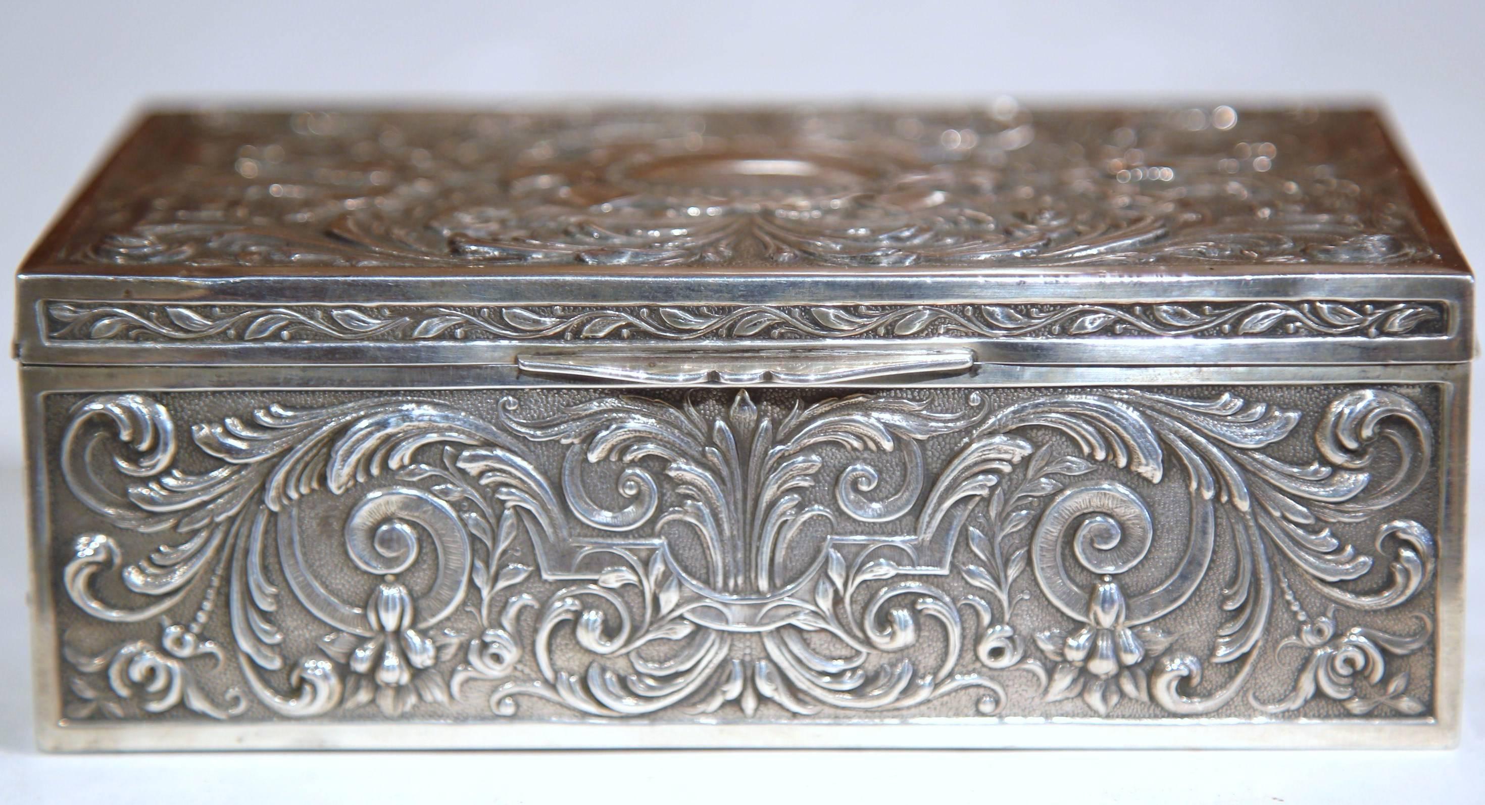 This small wooden and silver-plated jewelry box was crafted in France, circa 1890. The rectangular box is embellished with intricate repousse designs on the exterior and has a raw wood finish on the inside. The box is in excellent condition with