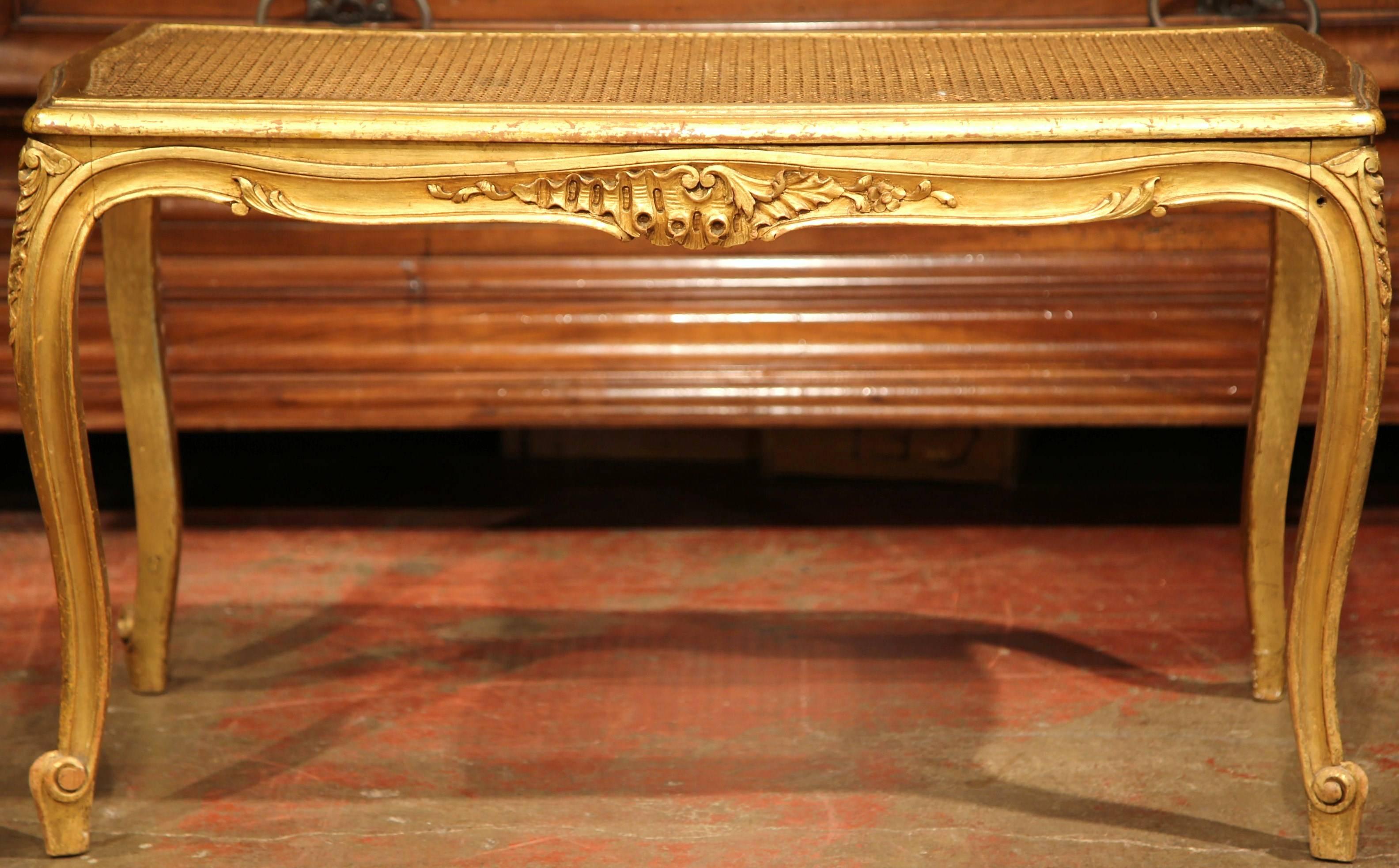 This elegant, hand carved giltwood bench was created in France, circa 1880. The antique piano seat seats on cabriole legs embellished with delicate, Louis XV carvings on the apron, and a cane seat also gilded on top. The bench is in excellent