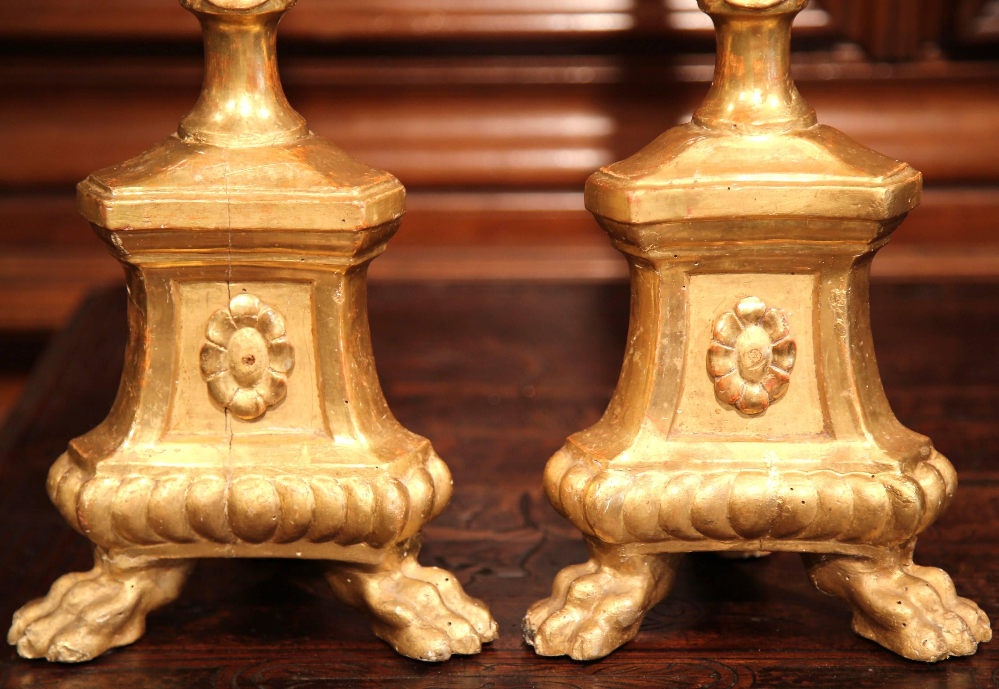 Decorate your dinner table or coffee table with this elegant pair of Italian carved wood, gesso, and gilt floral candlesticks. The prickets have a central spike to hold candles, and are decorated with bulbous ring columns with bead work, a medallion