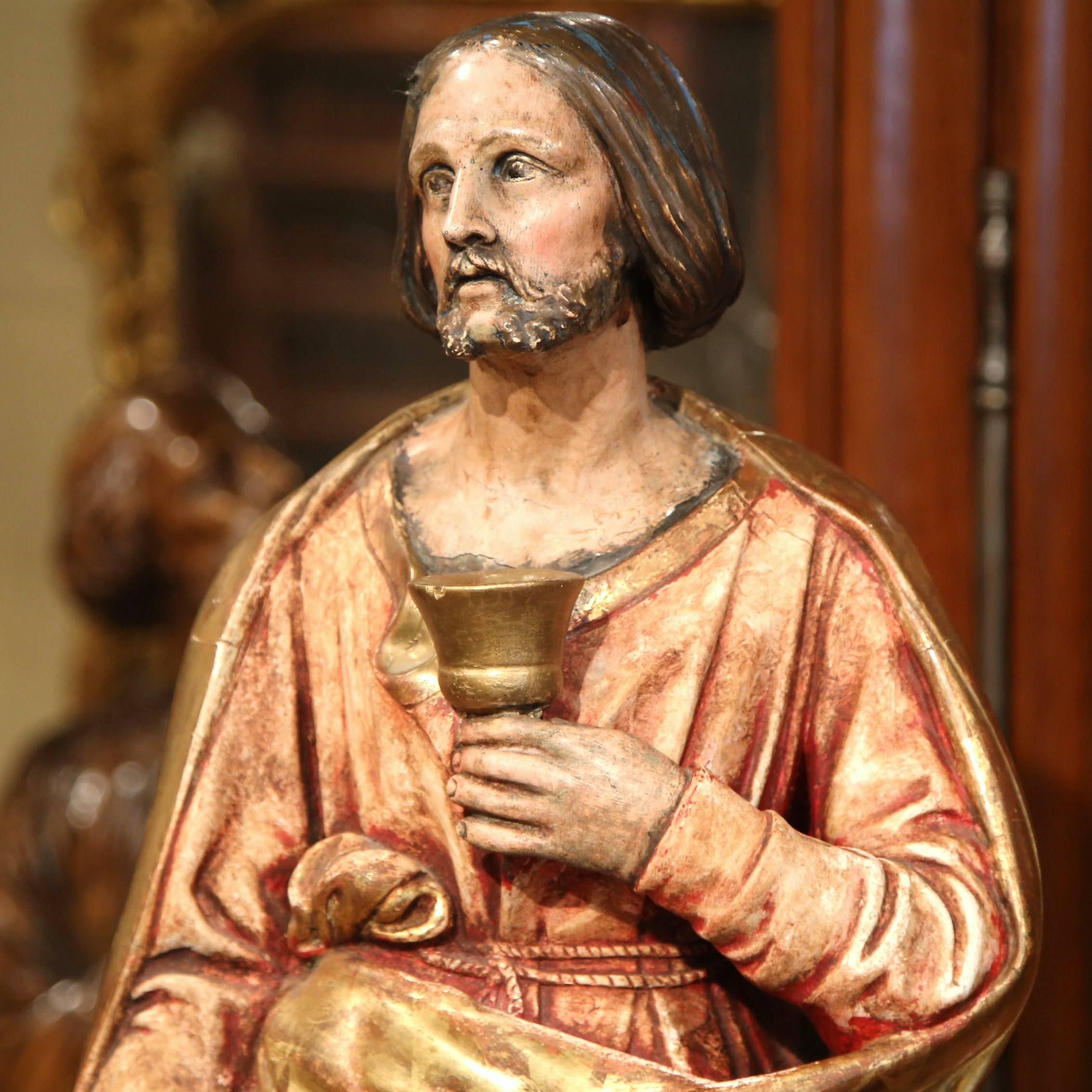 Make a statement in your home with this beautifully carved antique statue of Christ. Crafted in Southern France, circa 1820, the sculpture depicts the Lord holding a chalice with his robes draped around him. The religious figure has a nicely carved