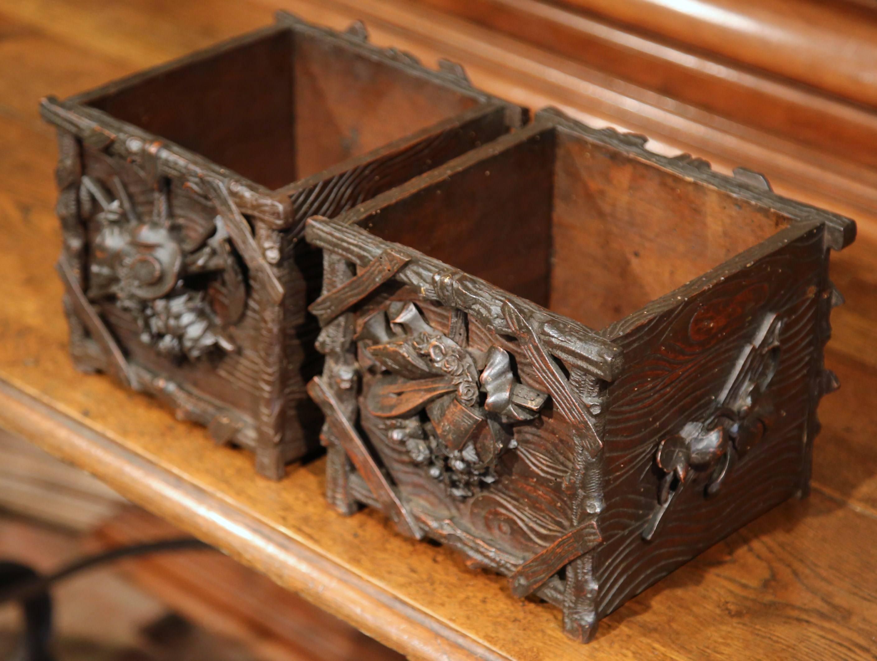 This pair of beautiful antique fruitwood cache pots were carved in the Alps of France, circa 1870. Each square planter features intricate carving on all four sides. The rustic, decorative motifs are carved in high relief and include farmer's tools,