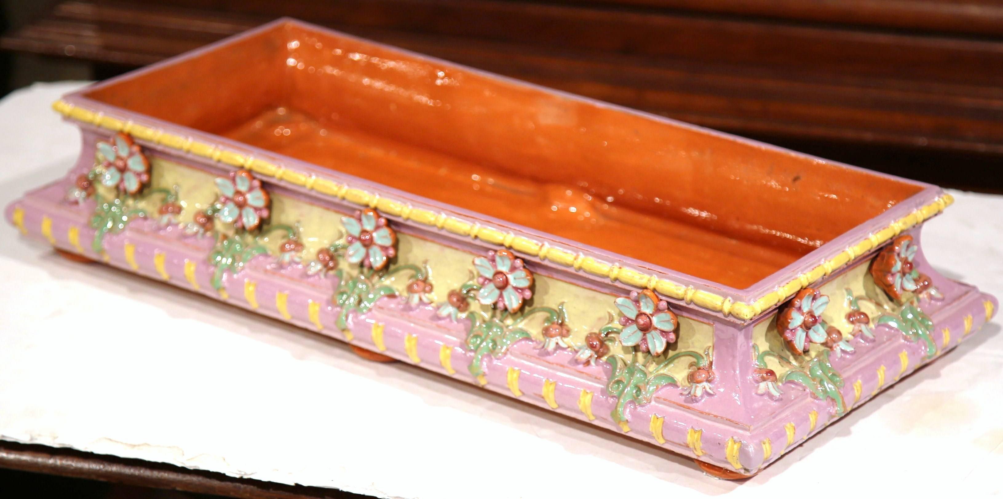 This beautifully crafted Majolica jardinière was sculpted in central France circa 1960. Painted in a feminine pink and yellow color palette, the ceramic would make a colorful addition to a tabletop in any room. The large, colorful planter is signed