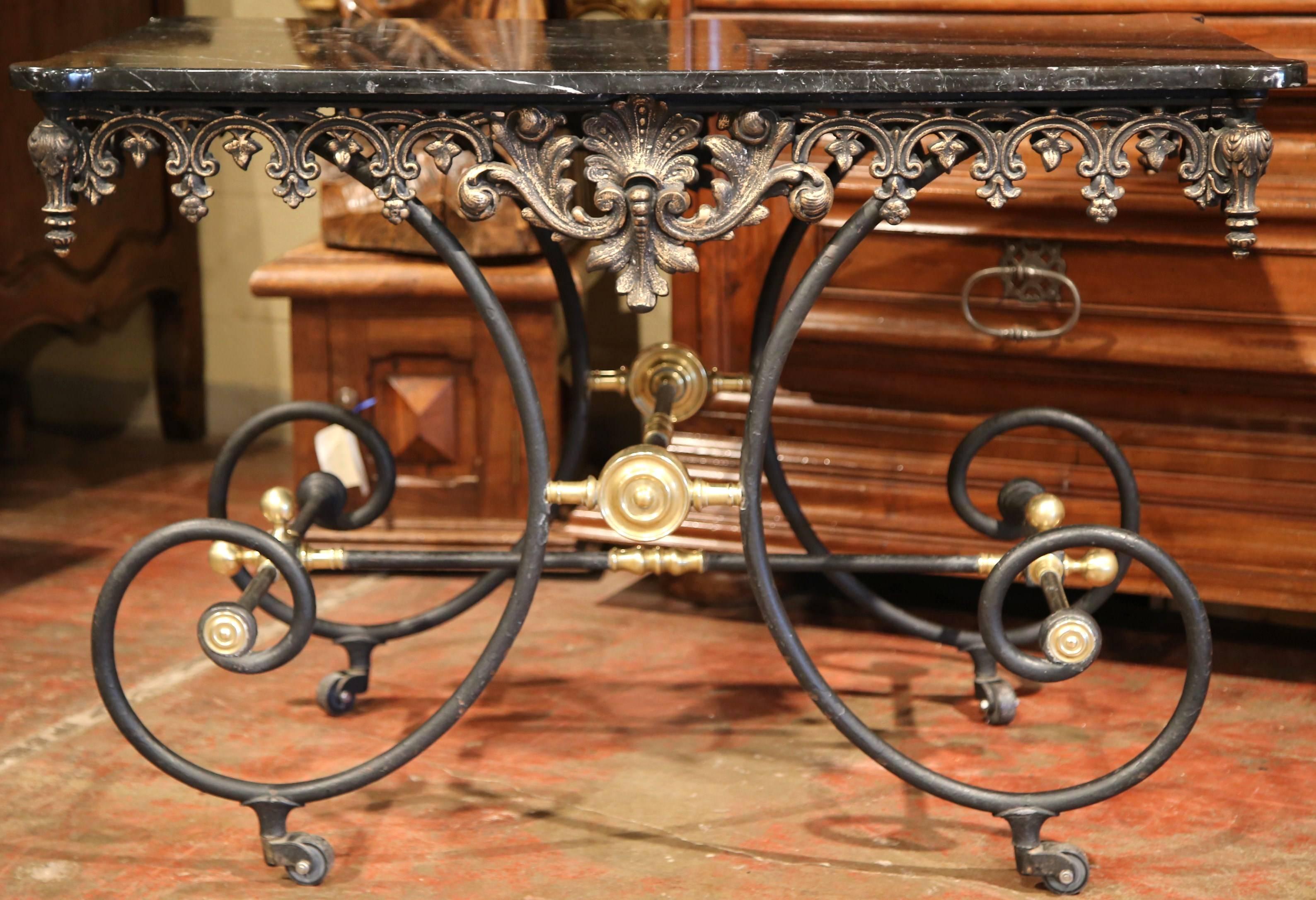This elegant, vintage butcher table (or pastry table), was crafted in France, circa 1950. The iron table on wheels, has intricate carving on the apron, beautifully scrolled legs and fine bronze decorative mounts. The embellished frame is topped with
