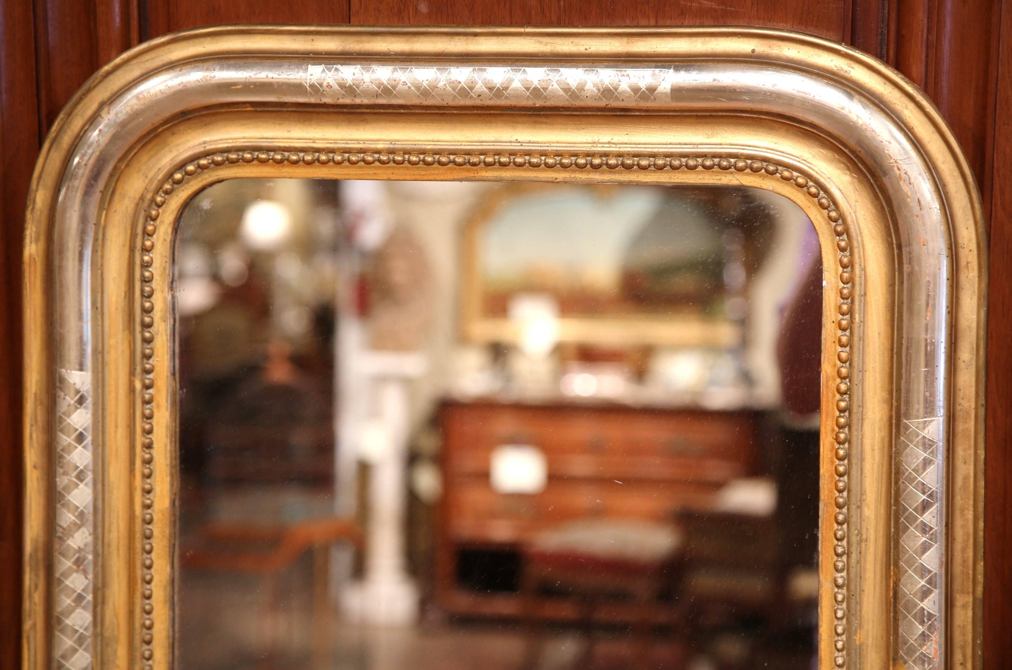 This elegant, small Louis Philippe mirror was crafted in France, circa 1860. The antique wall hanging mirror has a beautiful two-tone gold and silver leaf frame further embellished by beads around the frame, and engraved diamond decor on all four