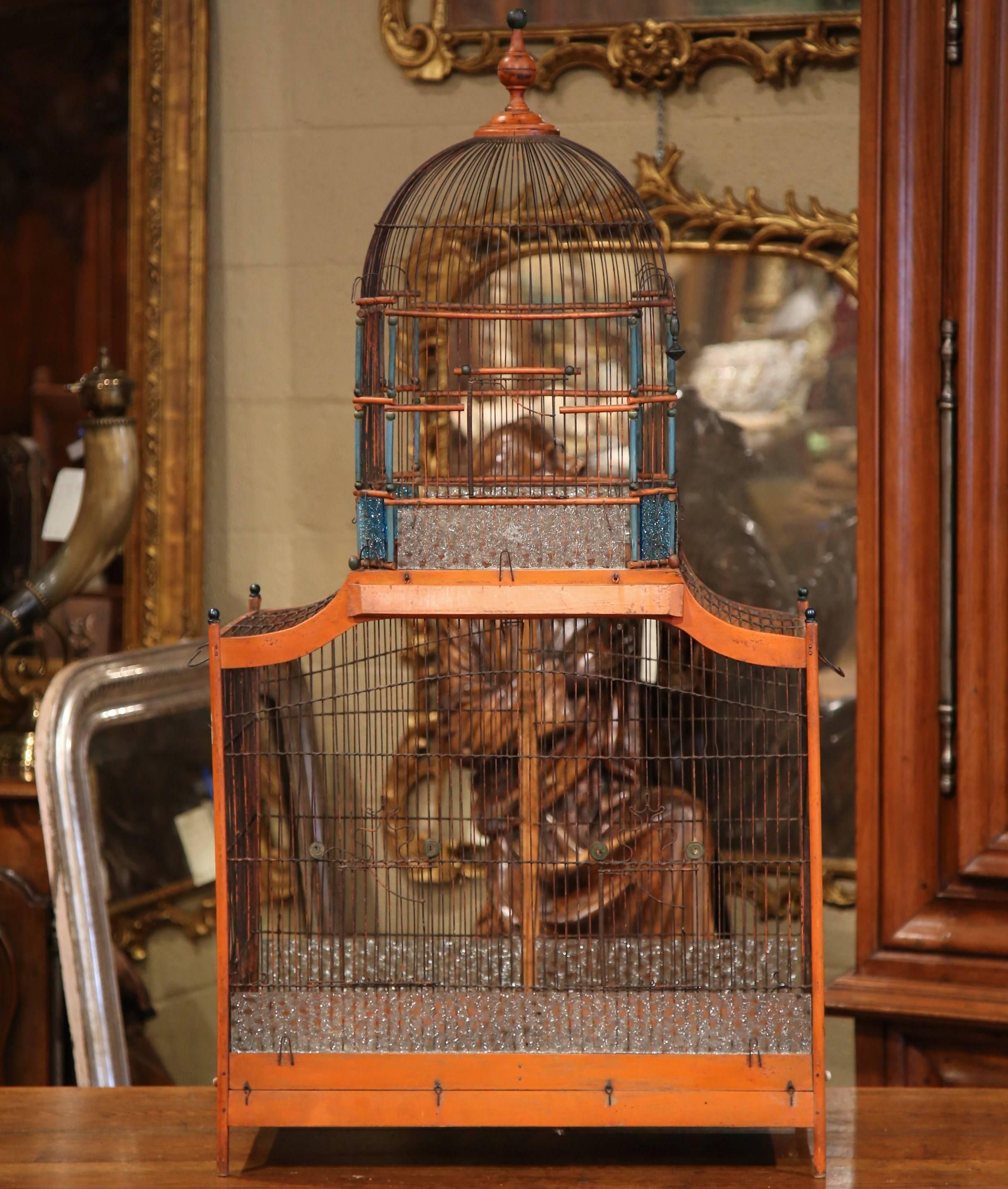 Bring the outdoors in with this large, elegant, antique birdcage. Crafted in France circa 1860, this hand painted cage features a rounded dome top with a decorative finial, and a larger rectangular birdhouse underneath. The entire two-tier cage is