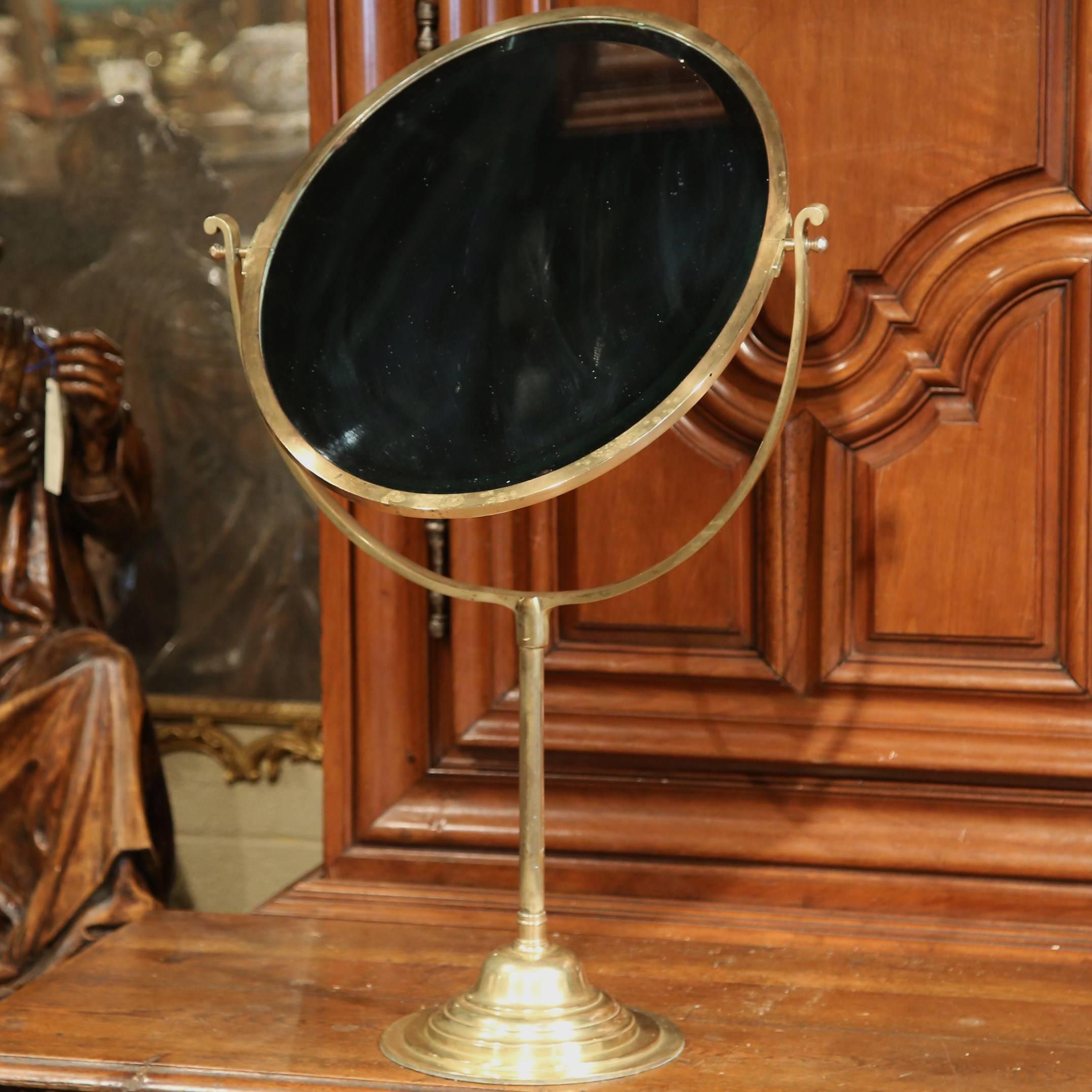 This exceptional, antique table mirror was crafted in France circa 1860. The elegant bronze piece sits on a single pedestal grounded with a round base. The mirror has a double sided, oval beveled glass that can be flipped as needed. Very good