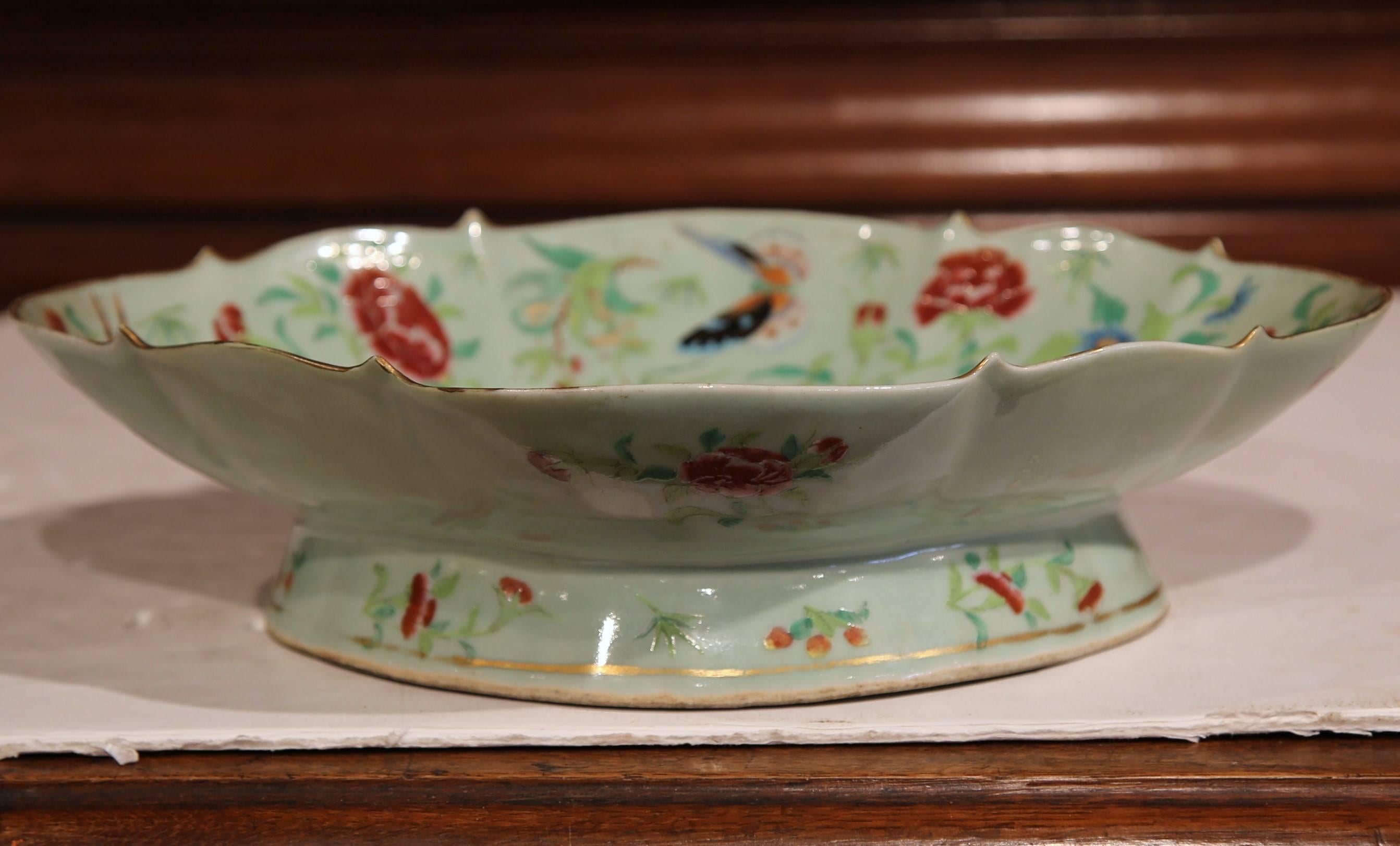 This colorful antique vide-poche was sculpted in China, circa 1860. The shallow, hand-painted porcelain tray features a large peacock in the center, another off to the side, and numerous butterflies and flower motifs throughout. The decorative