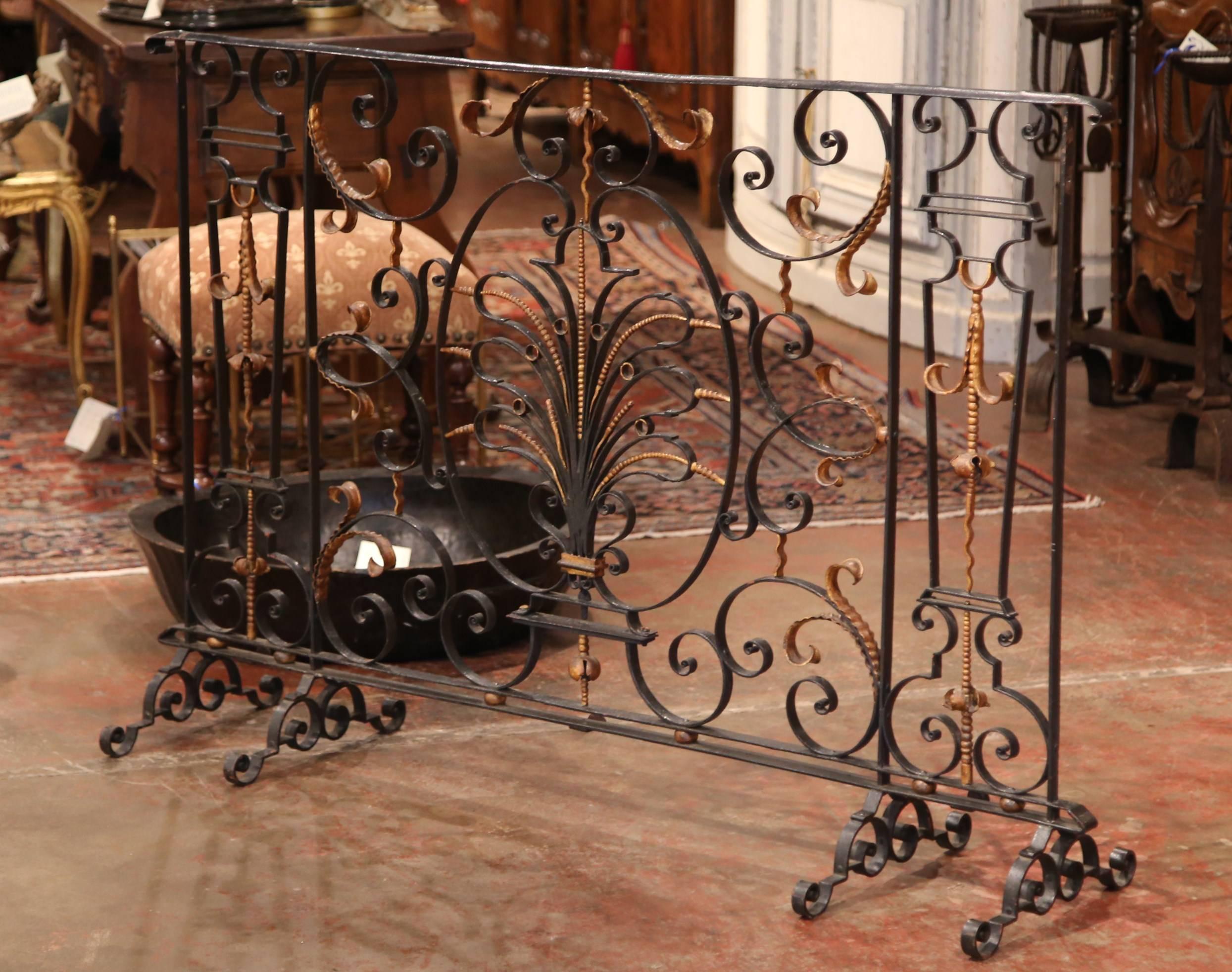 This beautifully forged antique balcony was crafted in France, circa 1780. The decorative balcony was transformed into a fireplace screen that features beautiful scrolled iron work with gilt accents. The black screen stands on four sturdy, cast iron