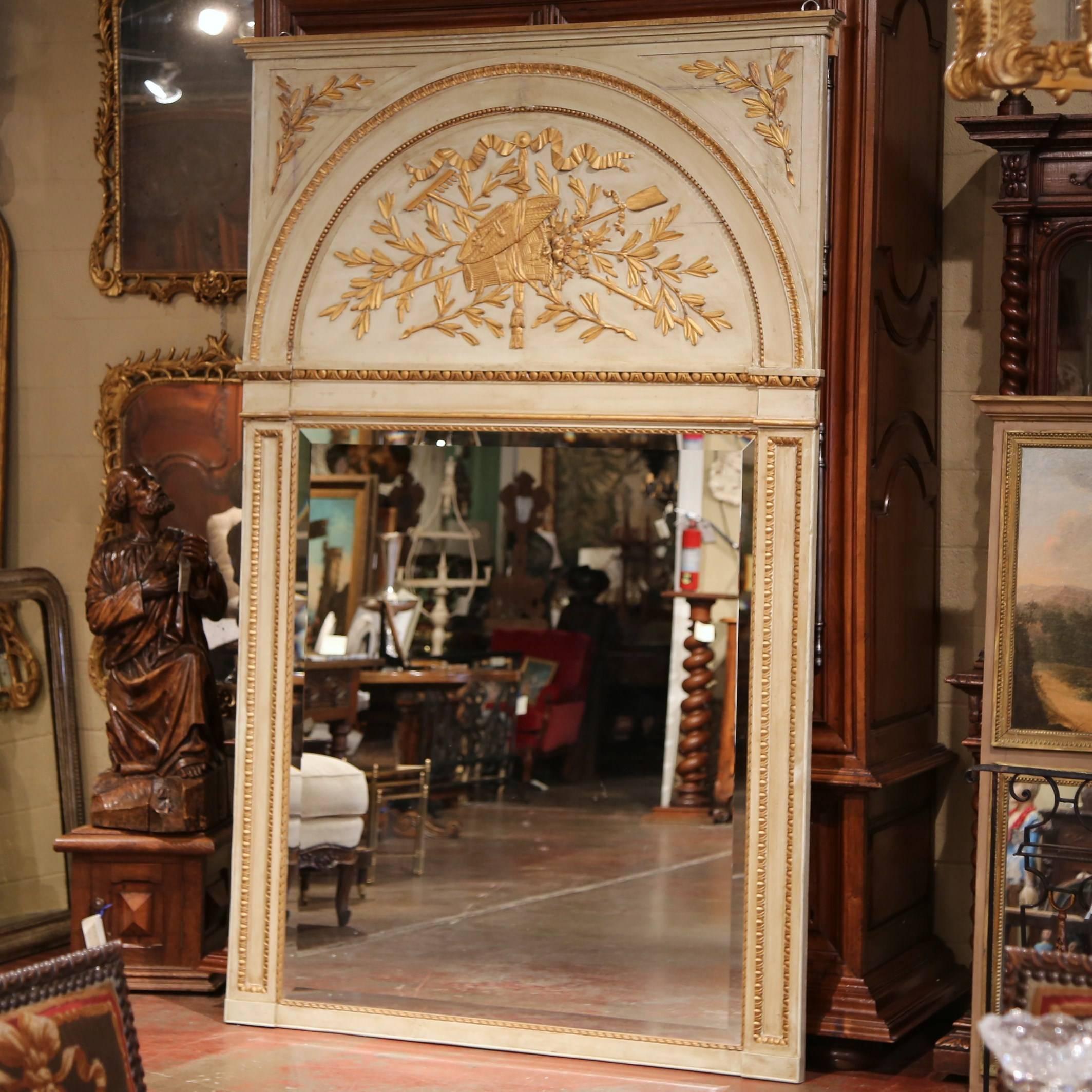 This large, antique trumeau was crafted in Southern France, circa 1860. The important antique frame features exquisite carvings on the arched pediment of rustic motifs including gardening tools, a grape basket and a straw hat; the motifs are